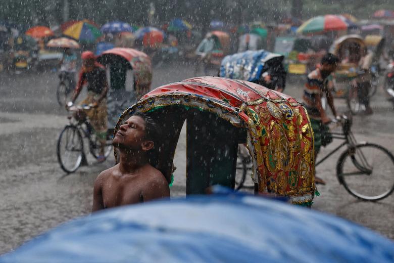 Vozač rikše uživa u kiši tokom monsuna u Daki, Bangladeš, 8. septembra. REUTERS/Mohammad Ponir Hossain
