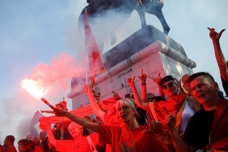 Žena pali baklju tokom protestnog skupa povodom nezvanične proslave Dana državnosti u Nikšiću, Crna Gora 13. jula. REUTERS/Stevo Vasiljević
