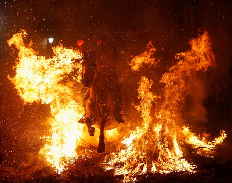 Jahač jaše kroz plamen tokom godišnje proslave "Luminarias" uoči dana Svetog Antuna, španskog zaštitnika životinja, u selu San Bartolome de Pinares, sjeverozapadno od Madrida, Španija 16. januara. REUTERS/Javier Barbancho
