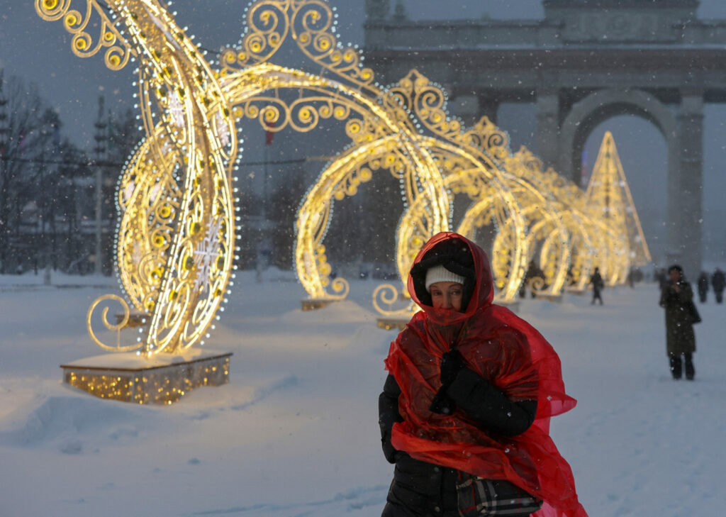 A woman walks past Christmas and New Year decoration during snowfall at the Exhibition of Achievements of National Economy (VDNKh) in Moscow