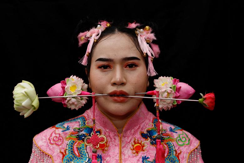 Žena sa probušenim ustima prikazana tokom ceremonije u hramu Jui Tui usred proslave godišnjeg vegetarijanskog festivala koji slave taoistički vjernici iz tajlandsko-kineske zajednice u devetom lunarnom mjesecu kineskog kalendara, u gradu Puket, Tajland. 2. oktobar. REUTERS/Jorge Silva