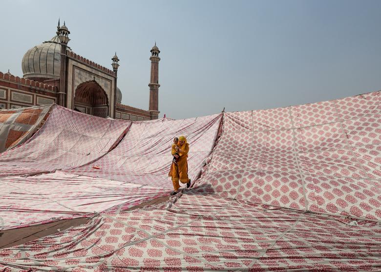 Muslimanka s djetetom odlazi nakon klanjanja namaza posljednjeg petka u svetom mjesecu posta Ramazana, u Jama Masjidu u staroj četvrti Delhija, Indija, 29. aprila. REUTERS/Anushree Fadnavis
