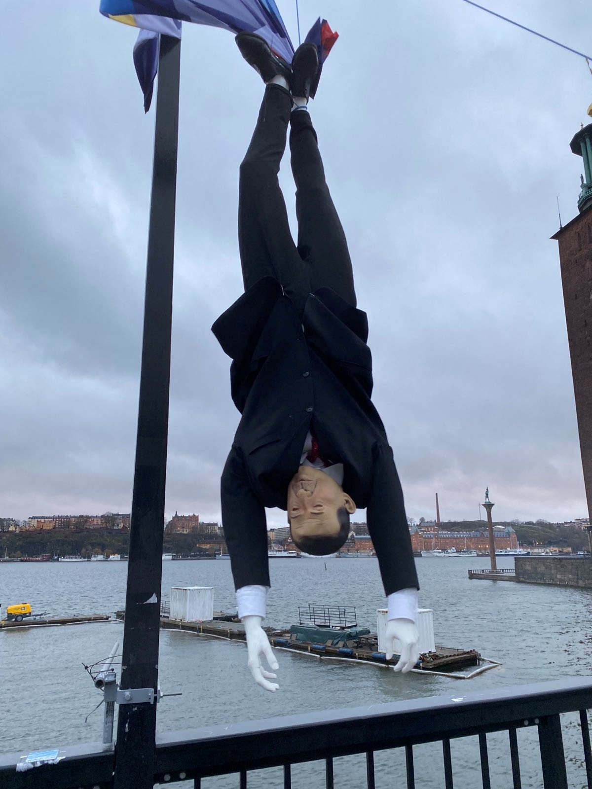 Puppet of Turkish President Erdogan is hung by its feet during demonstration in Stockholm