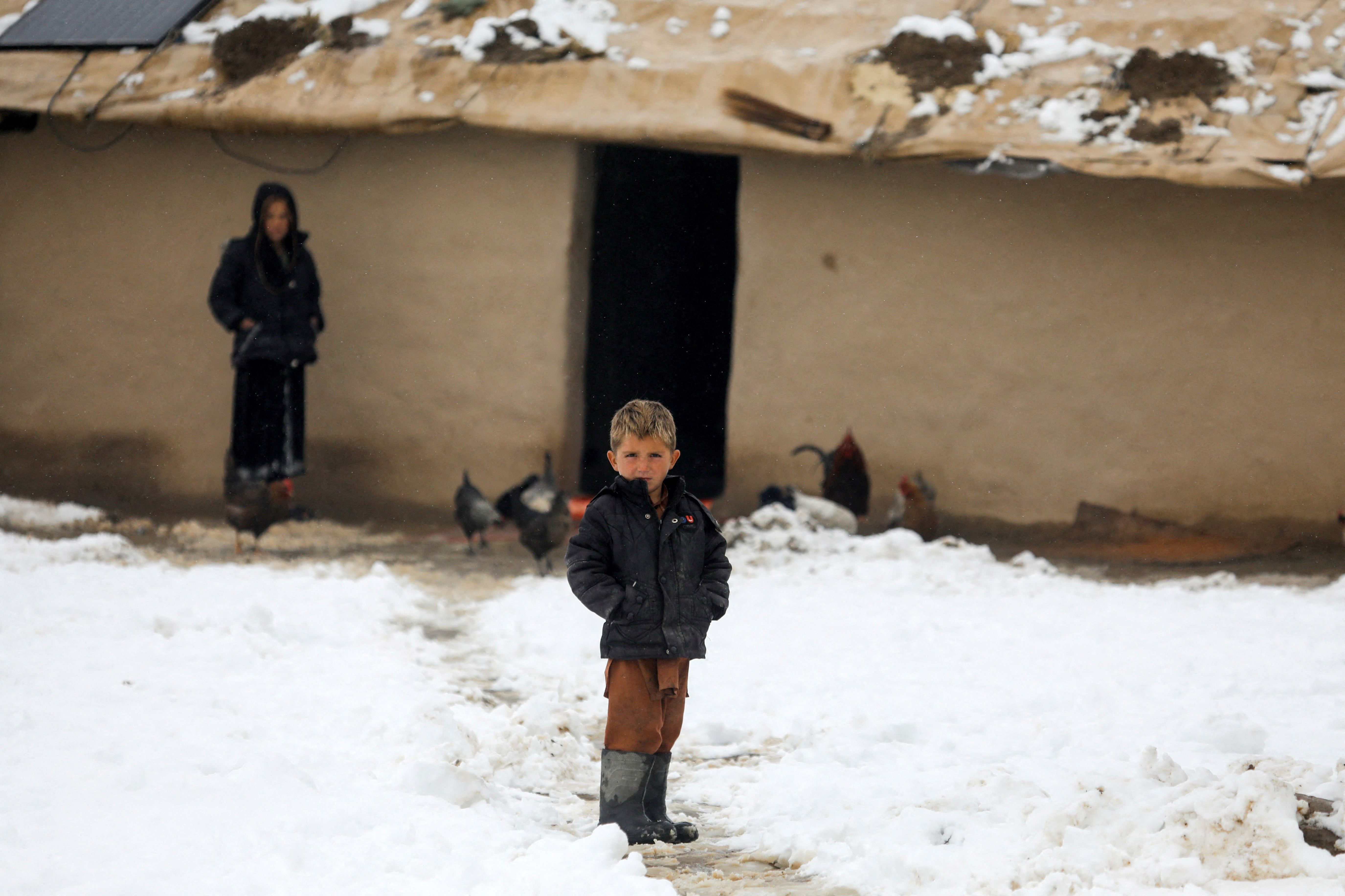 FILE PHOTO: An Afghan boy stands on snow-covered ground in Kabul