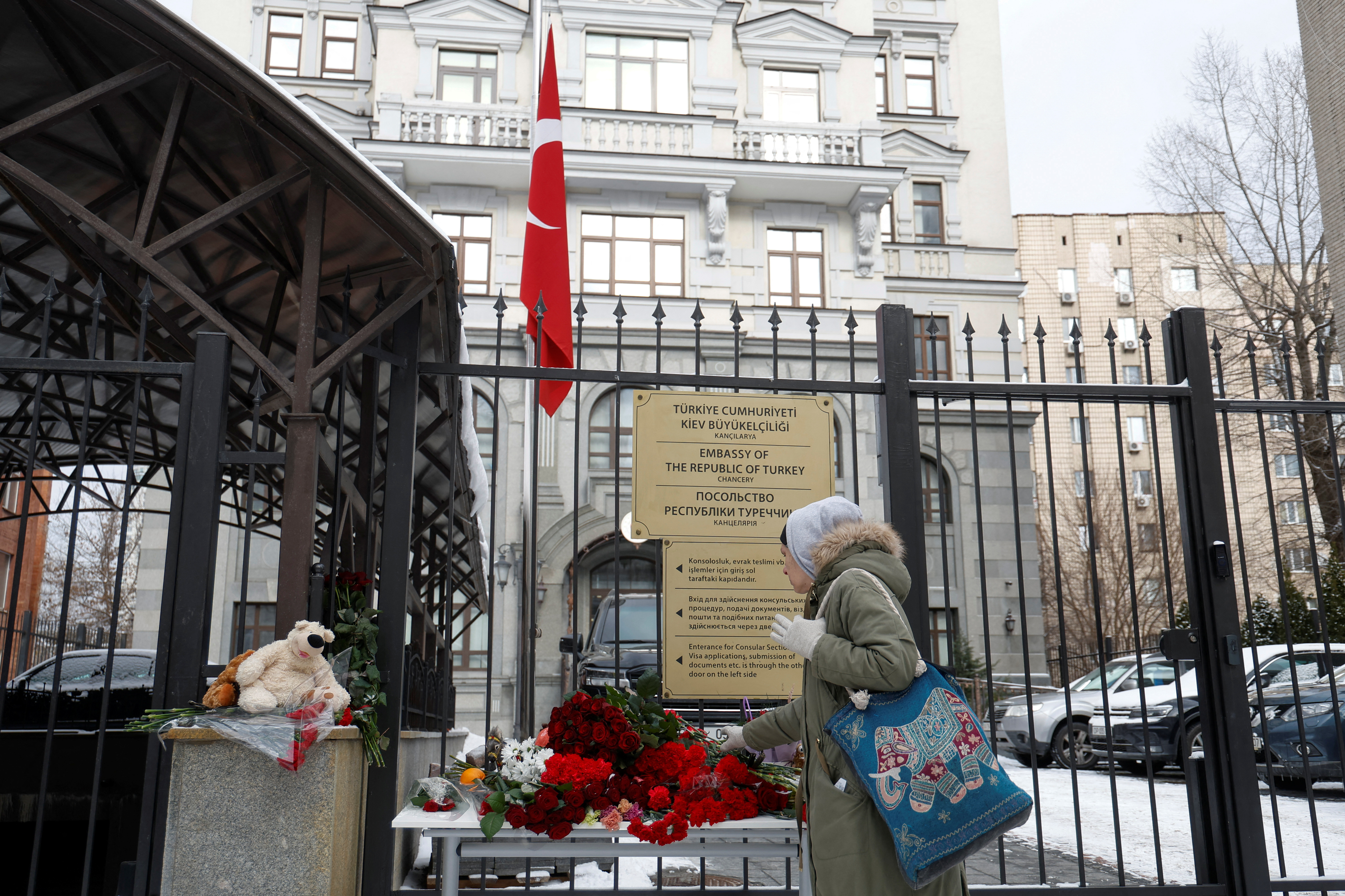 Woman lays flowers to pay tribute to the victims of an earthquake in Turkey and Syria, outside of the Turkish embassy in Kyiv
