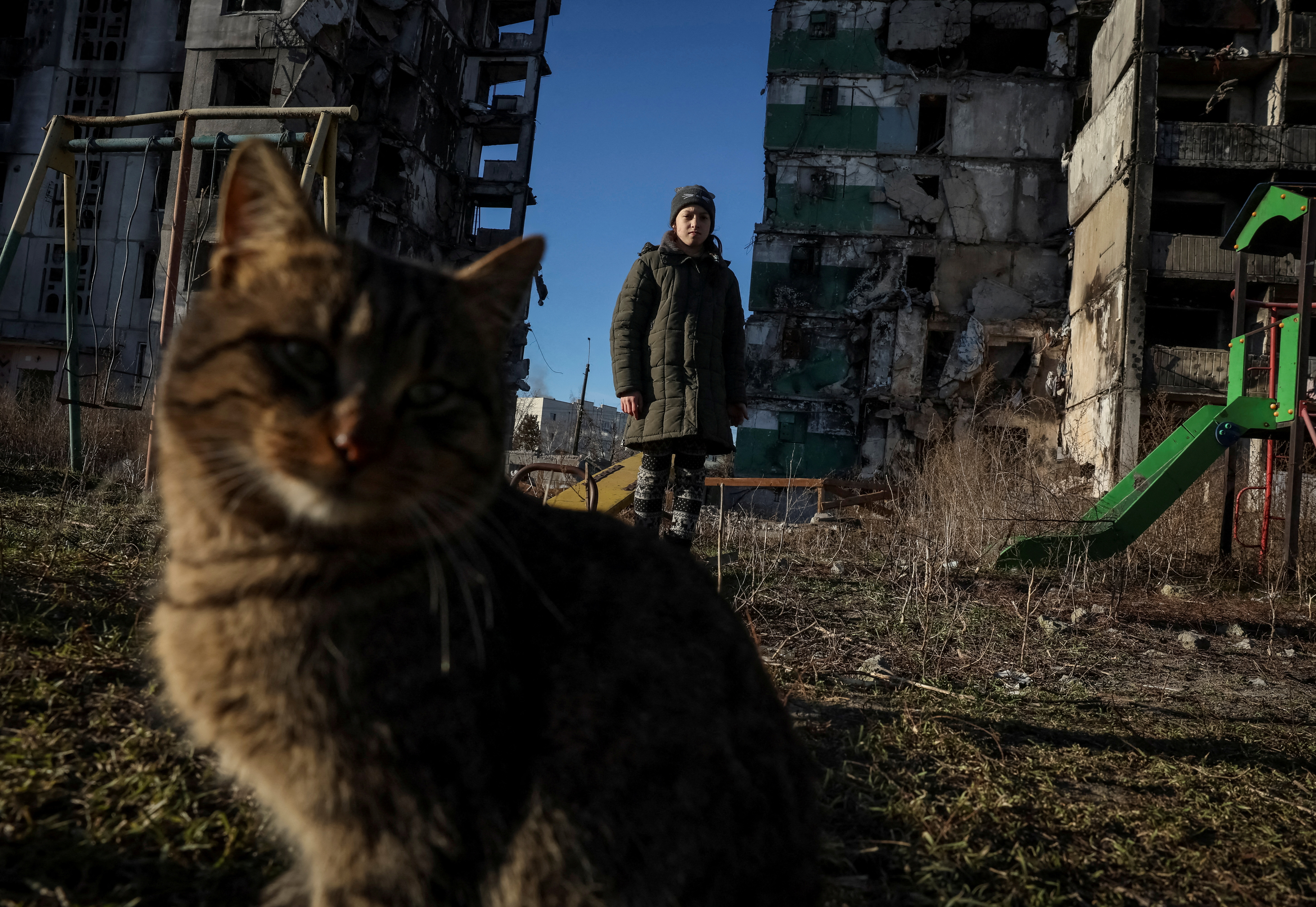 Veronika Krasevych, an 11-year-old Ukrainian girl stands next to a cat near her building destroyed by Russian military strike in the town of Borodianka heavily damaged during Russia's invasion of Ukraine, outside of Kyiv