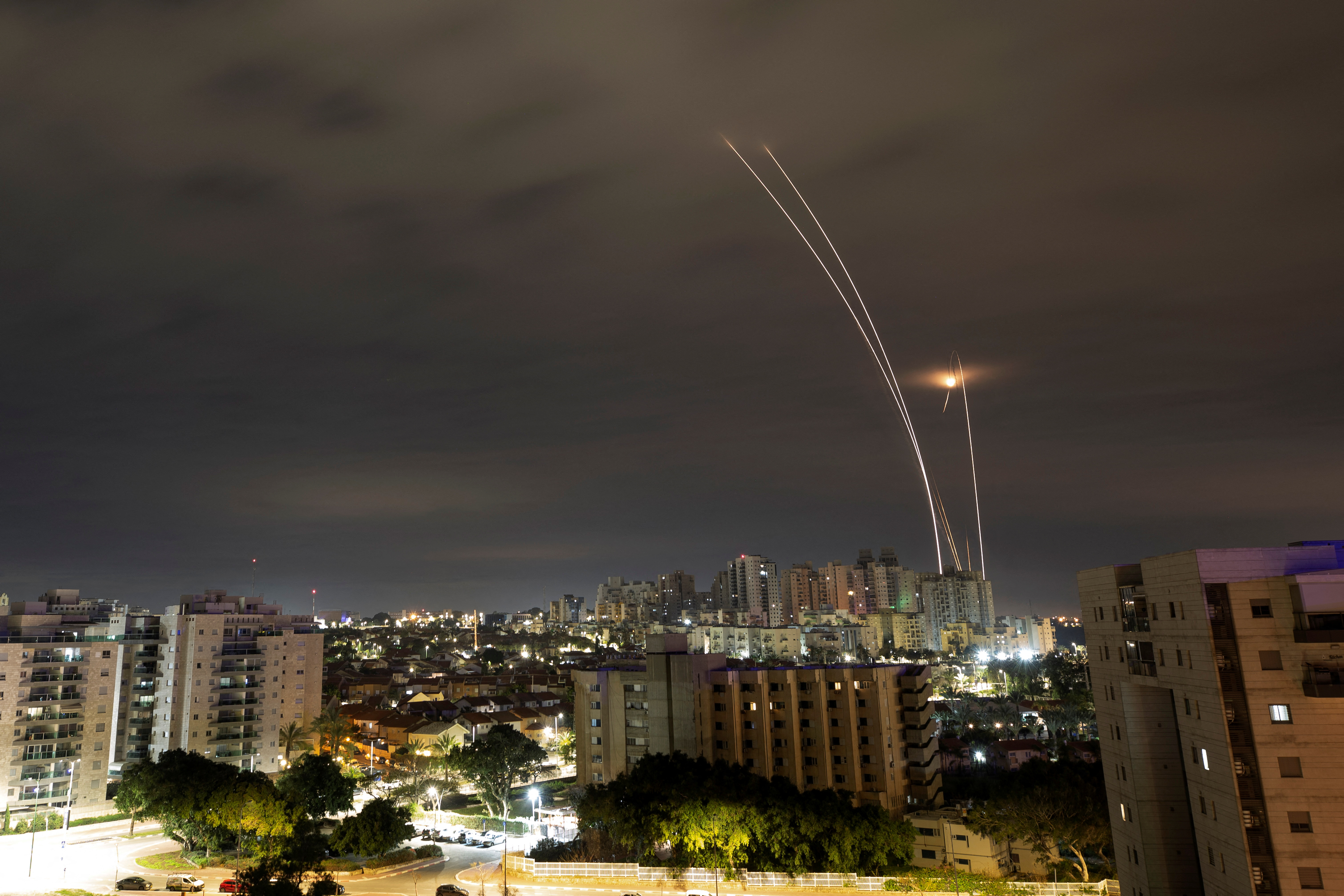 A trail of smoke is seen as rockets from Gaza are intercepted in the early morning, as seen from Ashkelon