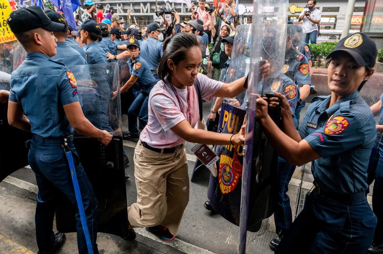 Žena pokušava da probije policijsku blokadu tokom protesta na Dan žena u Manili, Filipini, 8. marta 2023. REUTERS/Lisa Marie David