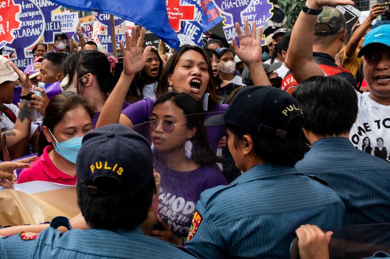 Filipinske žene i aktivisti pokušavaju da probiju policijsku blokadu tokom protesta na Dan žena, u Manili, Filipini, 8. marta 2023. REUTERS/Lisa Marie David