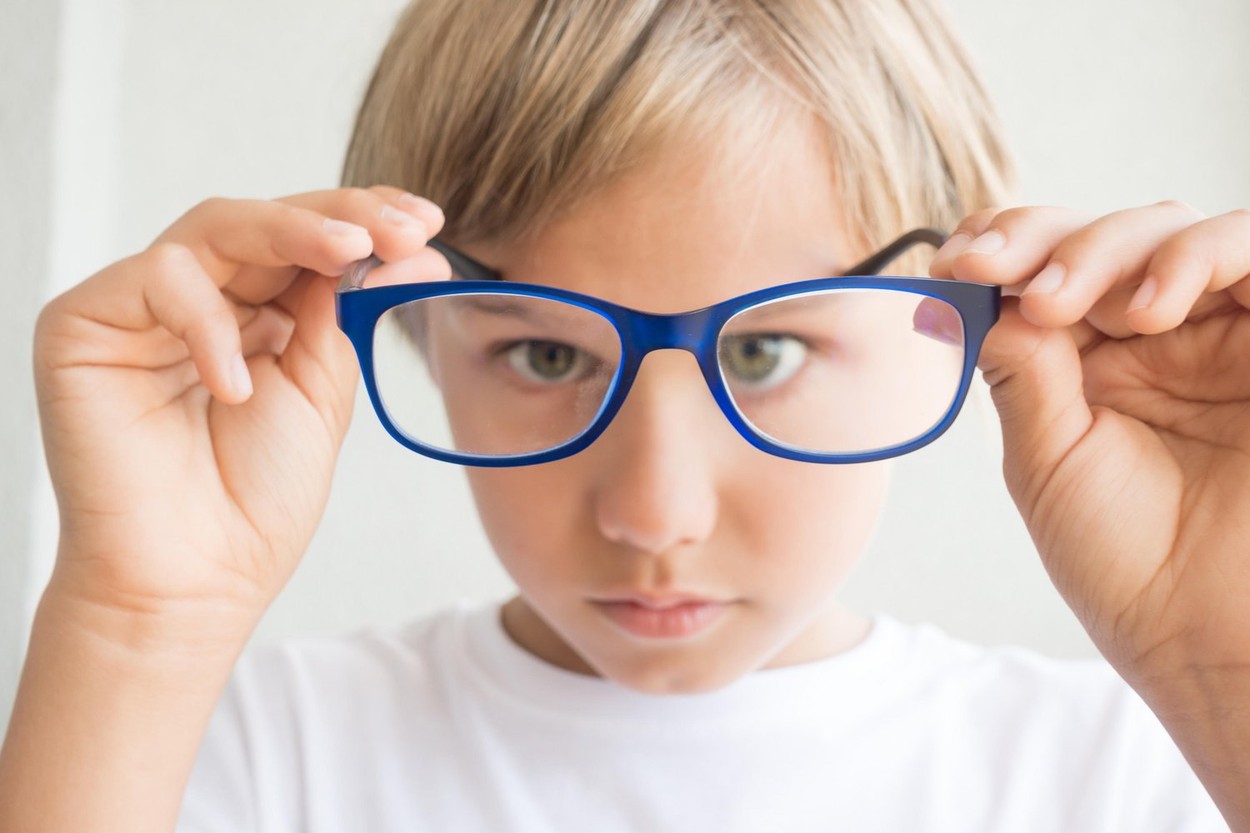 Child holding glasses and looking through it