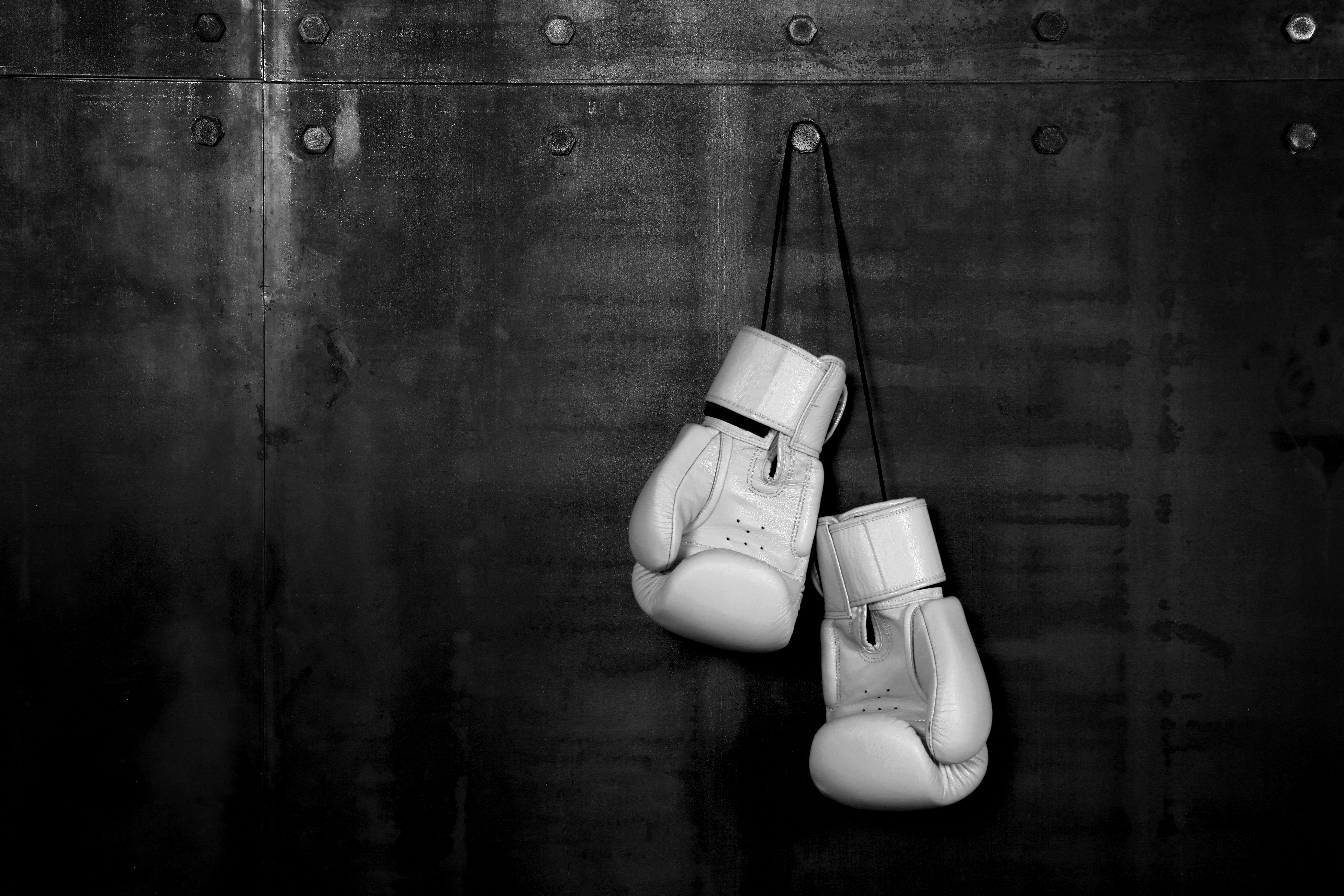 Close,Up,Pair,Of,White,Leather,Boxing,Gloves,Hanging,Over
