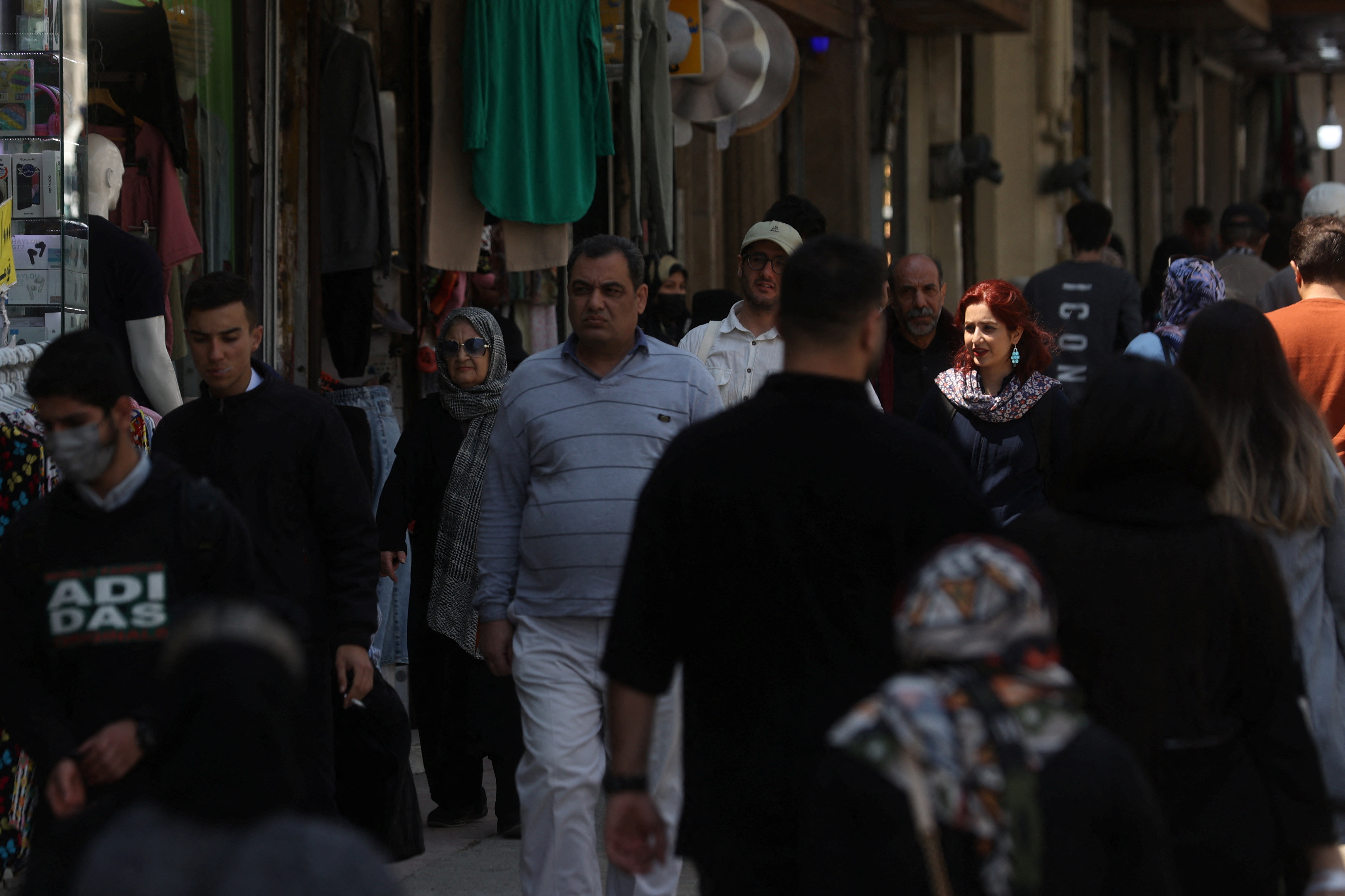 People walk on a street amid the implementation of the new hijab surveillance in Tehran