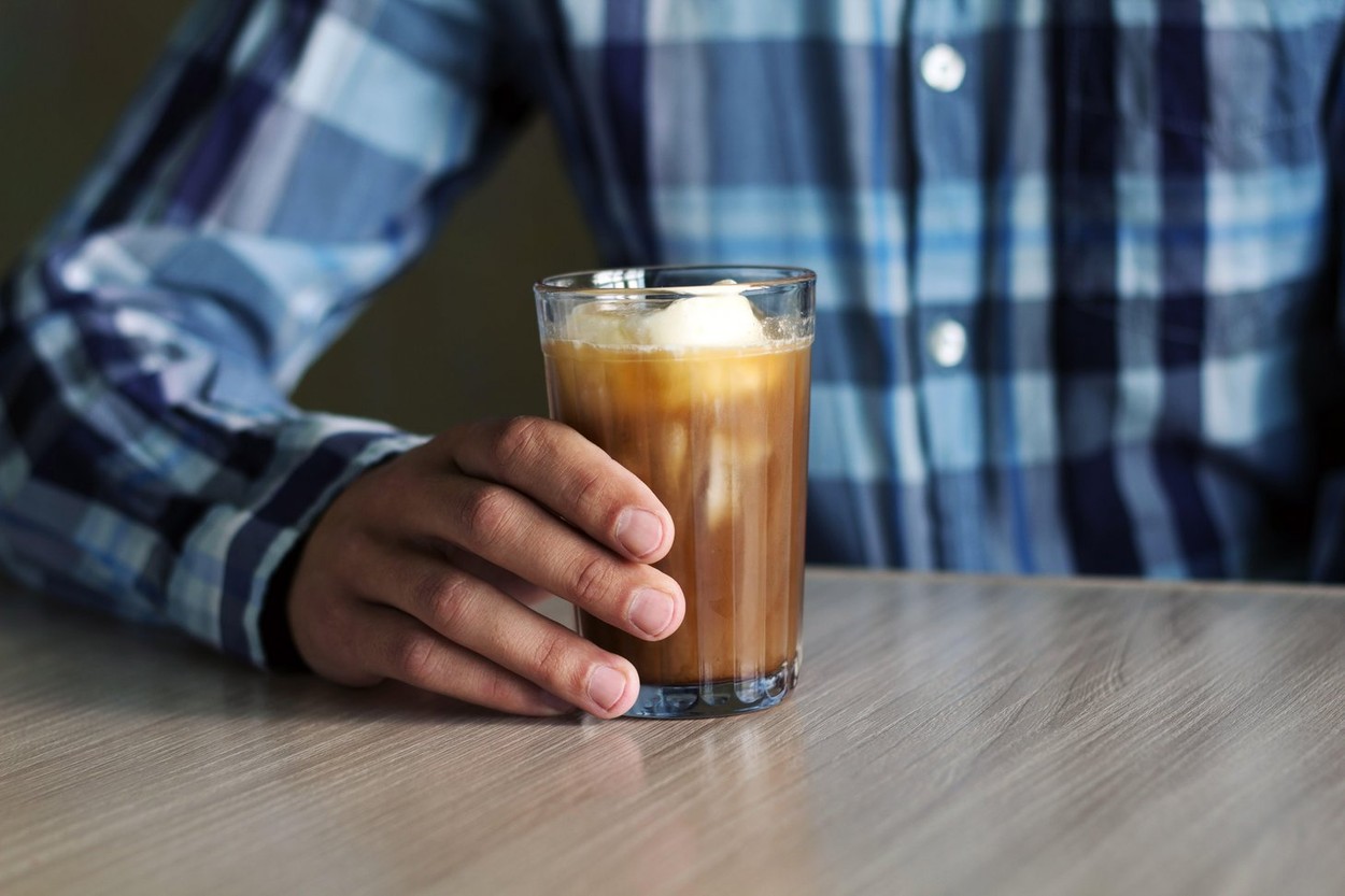 man with iced coffee at the coffee shop