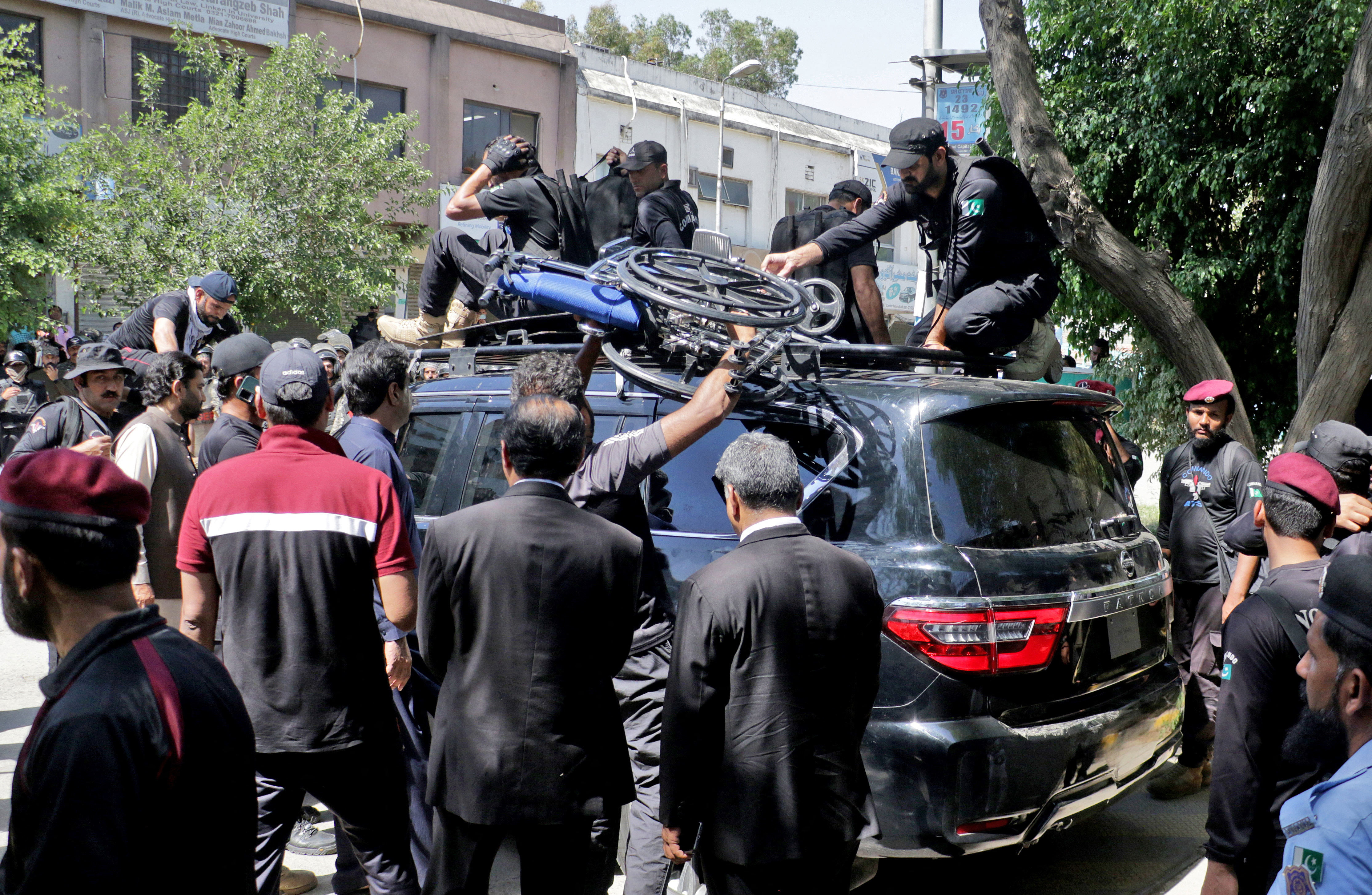 Pakistan security forces guard a vehicle carrying former Prime Minister Imran Khan after his arrest at a court in Islamabad