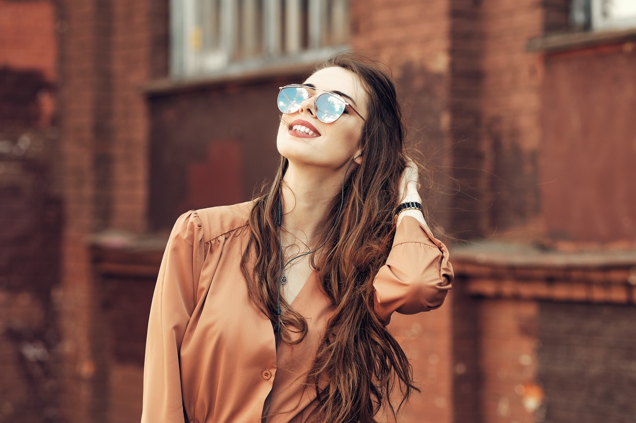 Young woman with long curly hair in sunglasses