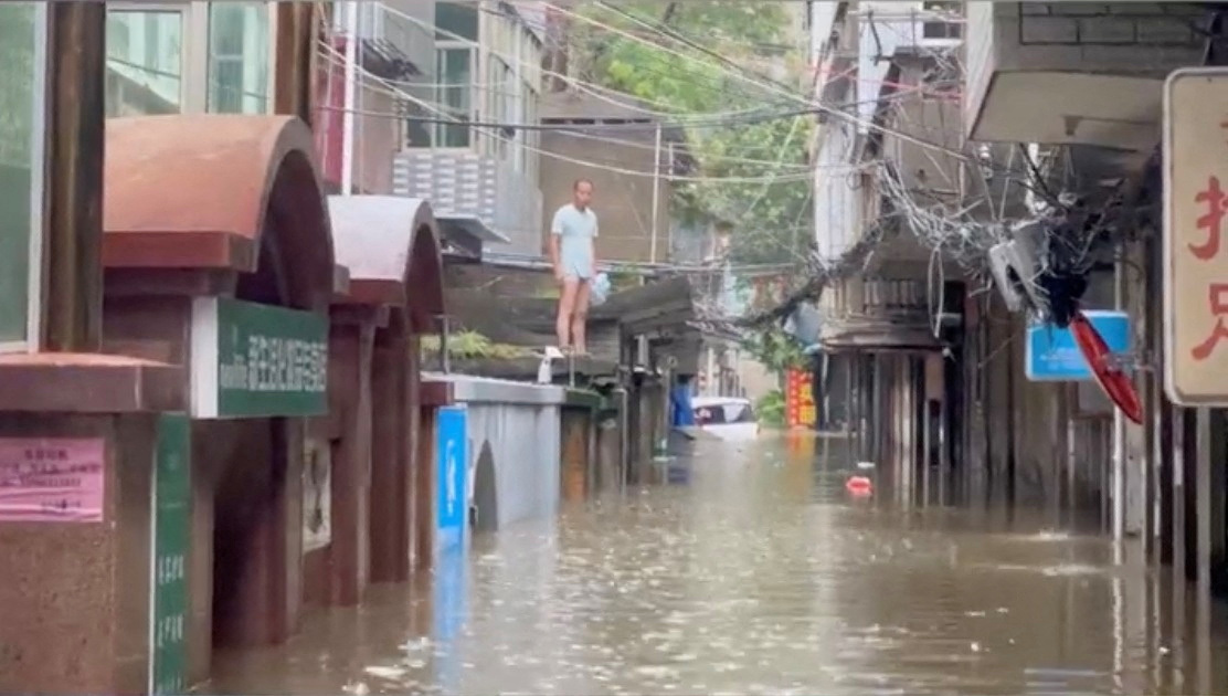 A resident stranded by floodwaters looks on following heavy rainfall brought by Typhoon Talim, in Fuzhou