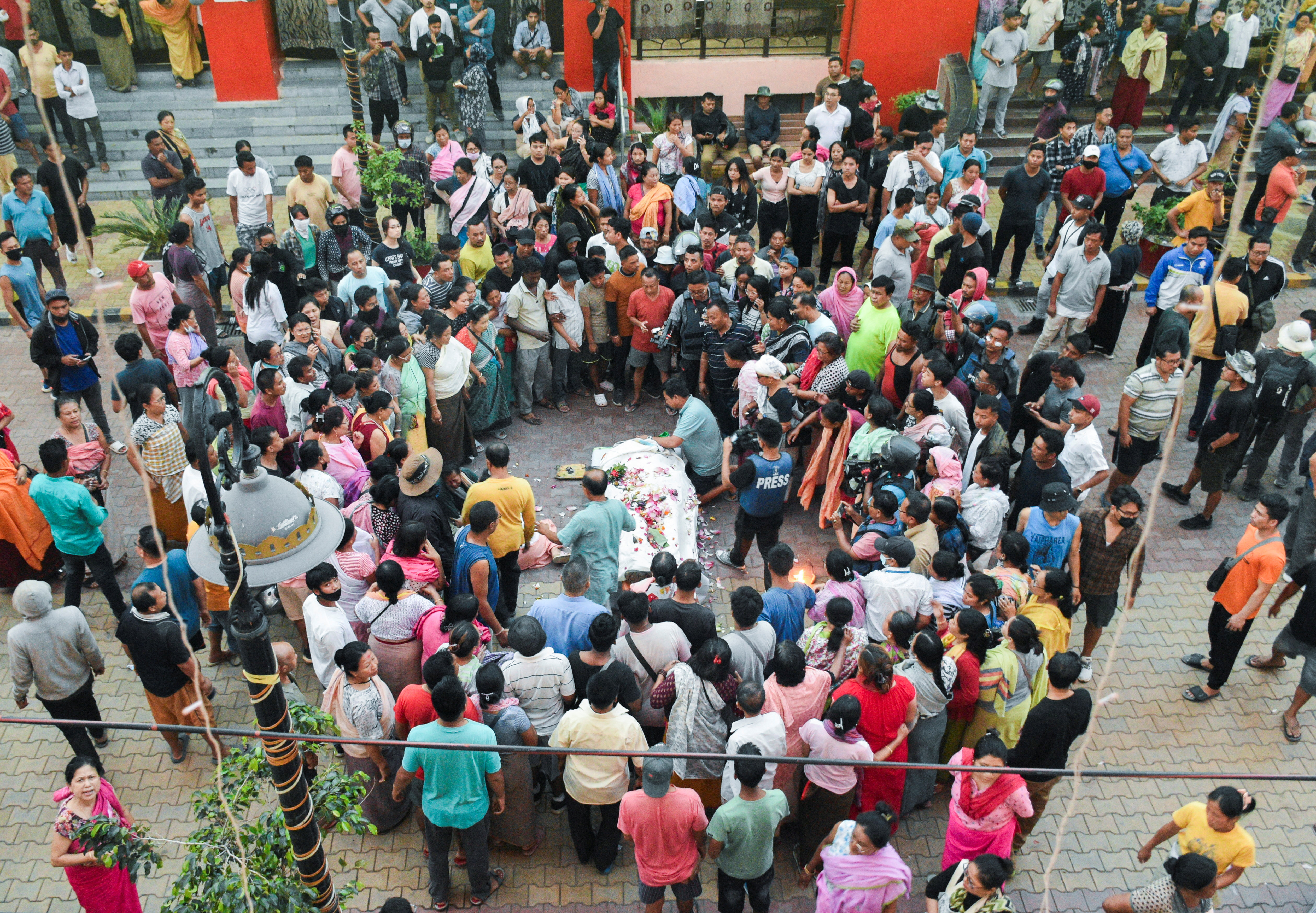 People offer condolence as they gather around the body of a man killed in a violence between ethnic groups in northeastern state of Manipur