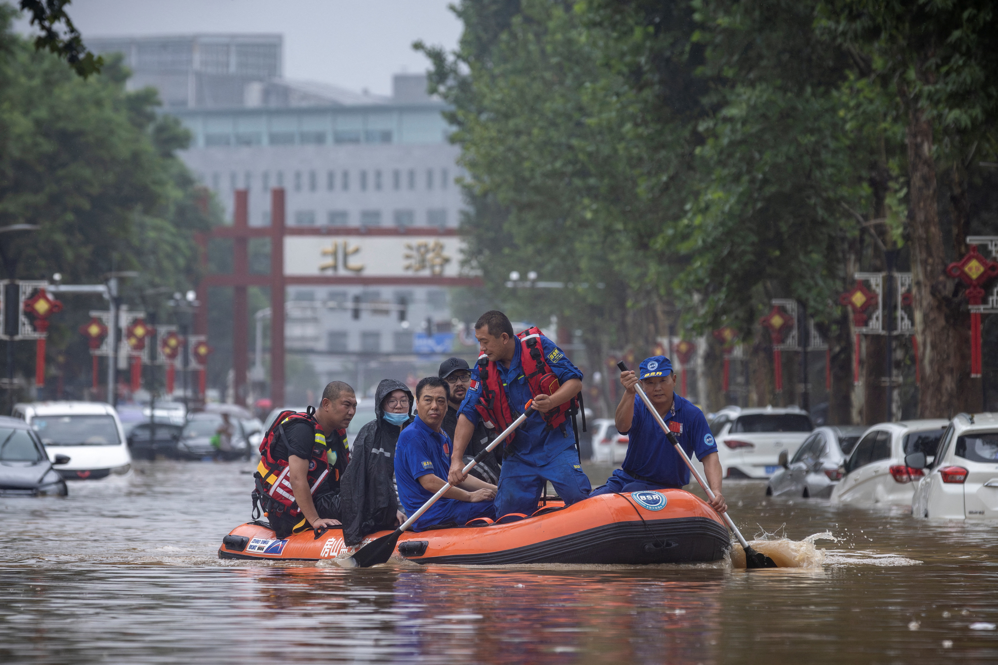 Rescue workers in a boat go through a flooded street in a neighbourhood where days of heavy rain from remnants of Typhoon Doksuri have caused heavy damage in Beijing