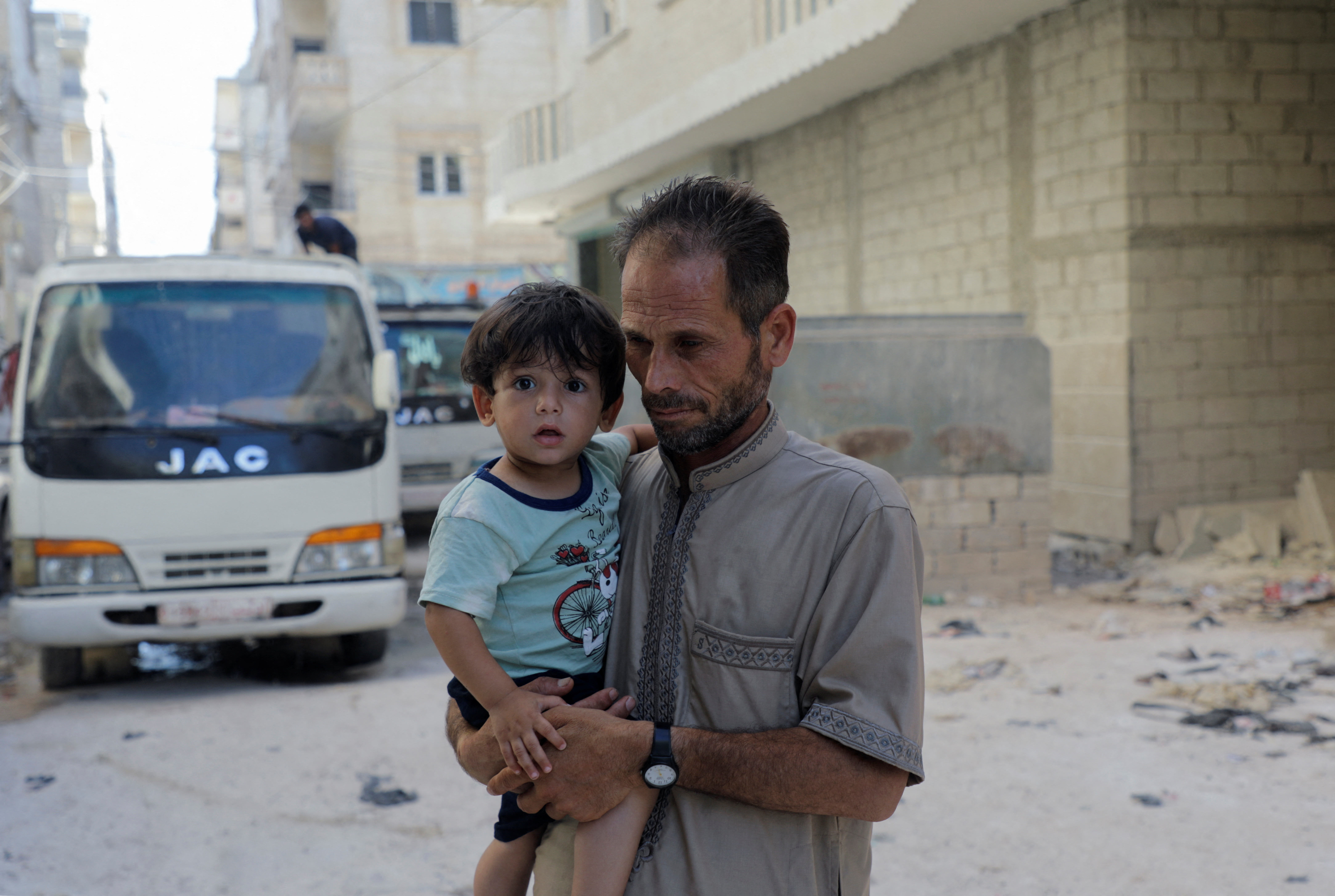 Syrian father and quake survivor, Jomaa Biazid, holds his son Ibrahim in al-Dana town