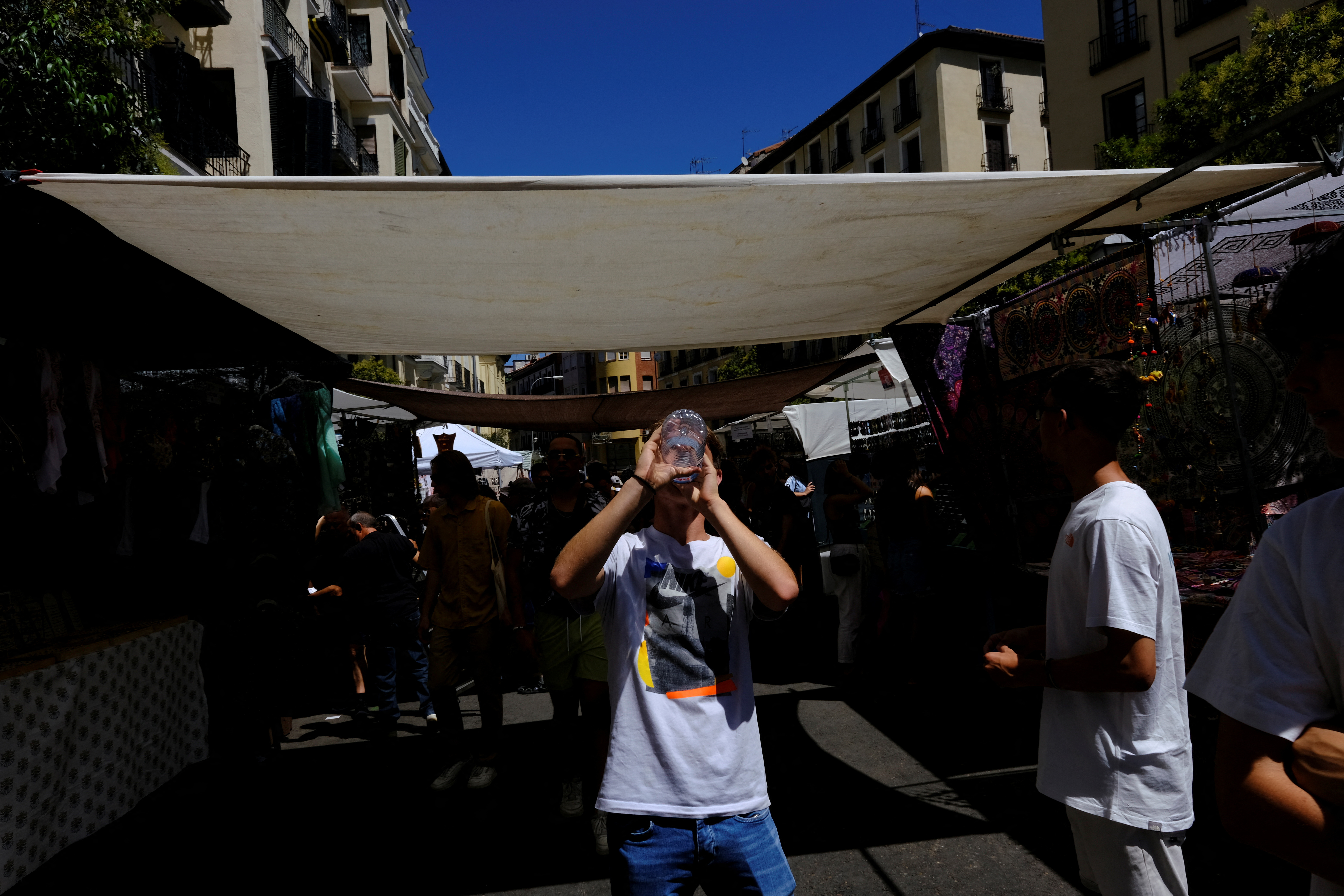 People visit the Rastro open-air market during a hot summer day in Madrid
