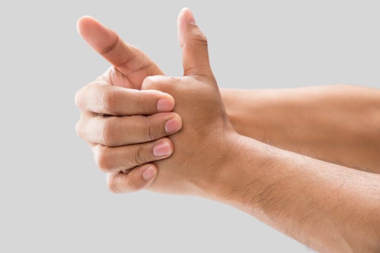 A,Man,Cracking,Their,Knuckles,,On,A,Gray,Background.