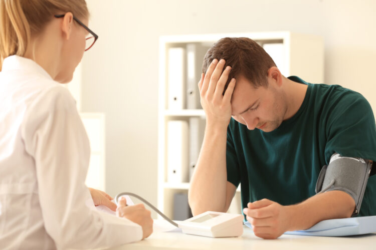 Female,Doctor,Measuring,Blood,Pressure,Of,Male,Patient,In,Hospital