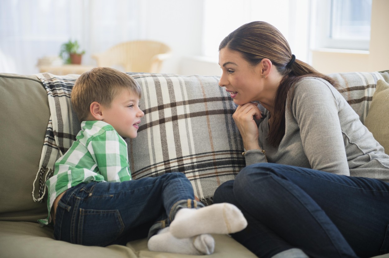 Mother and son (6-7) sitting on sofa