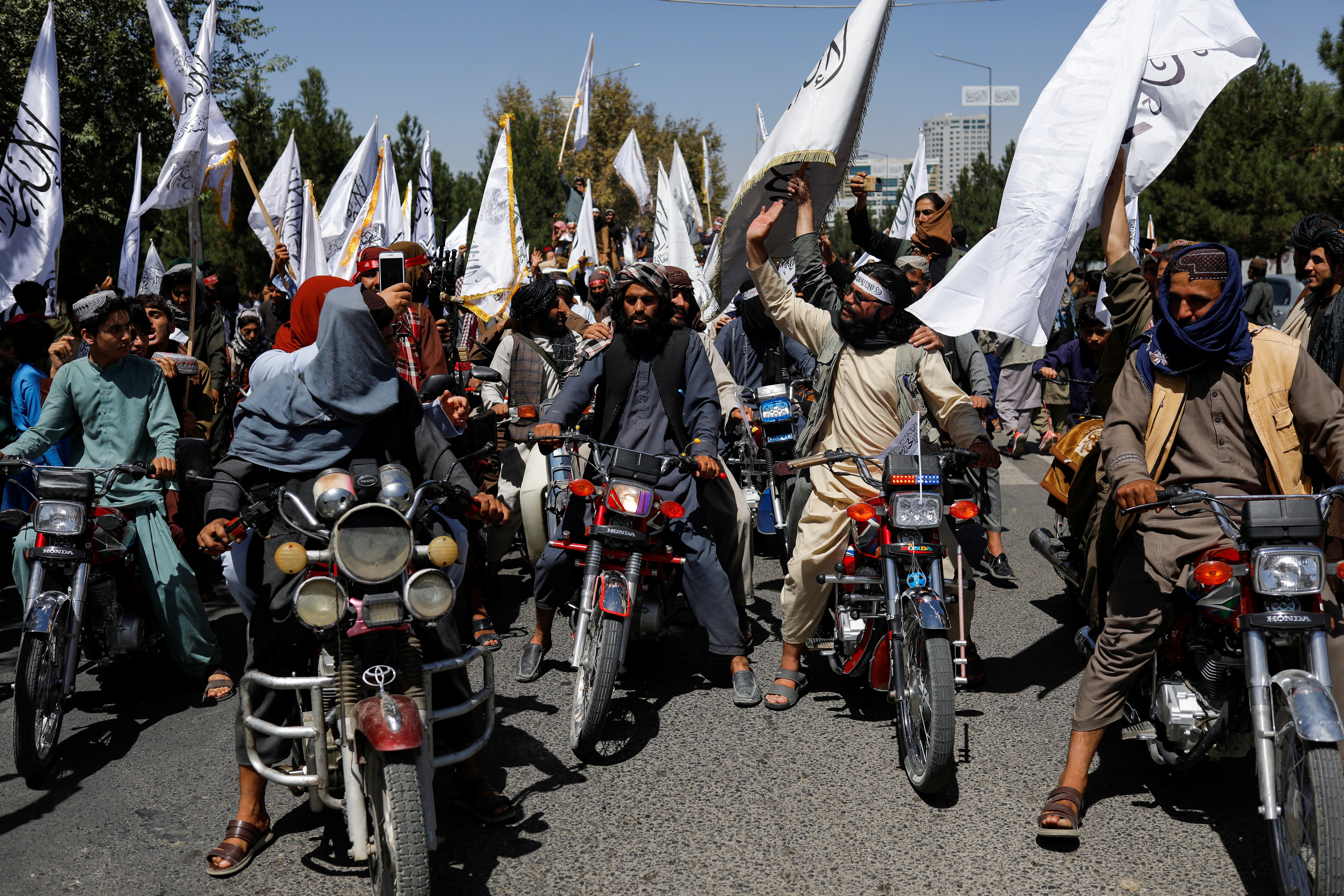 Taliban members celebrate on the second anniversary of the fall of Kabul on a street near the US embassy in Kabul