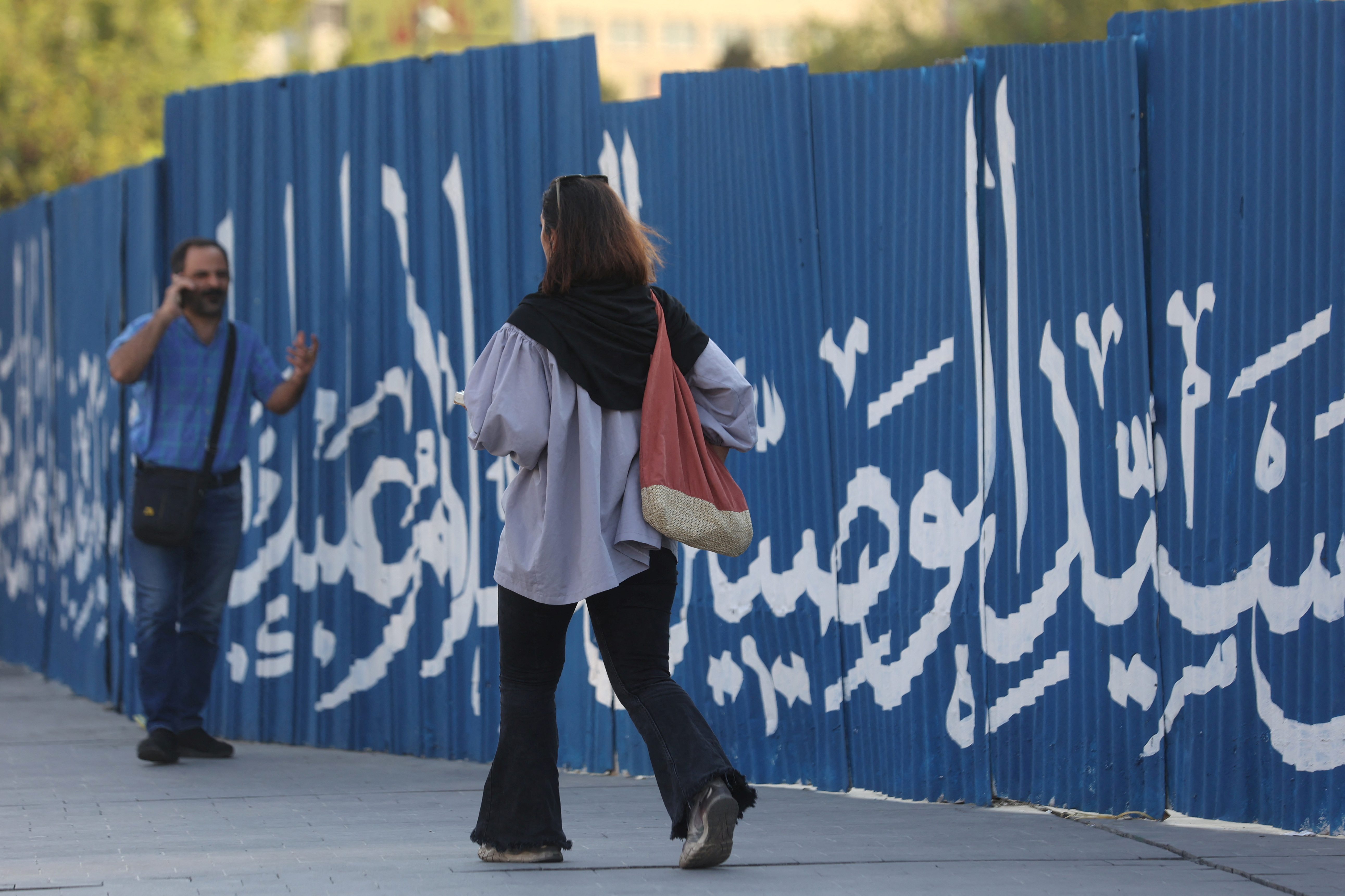 An Iranian woman walks on a street in Tehran