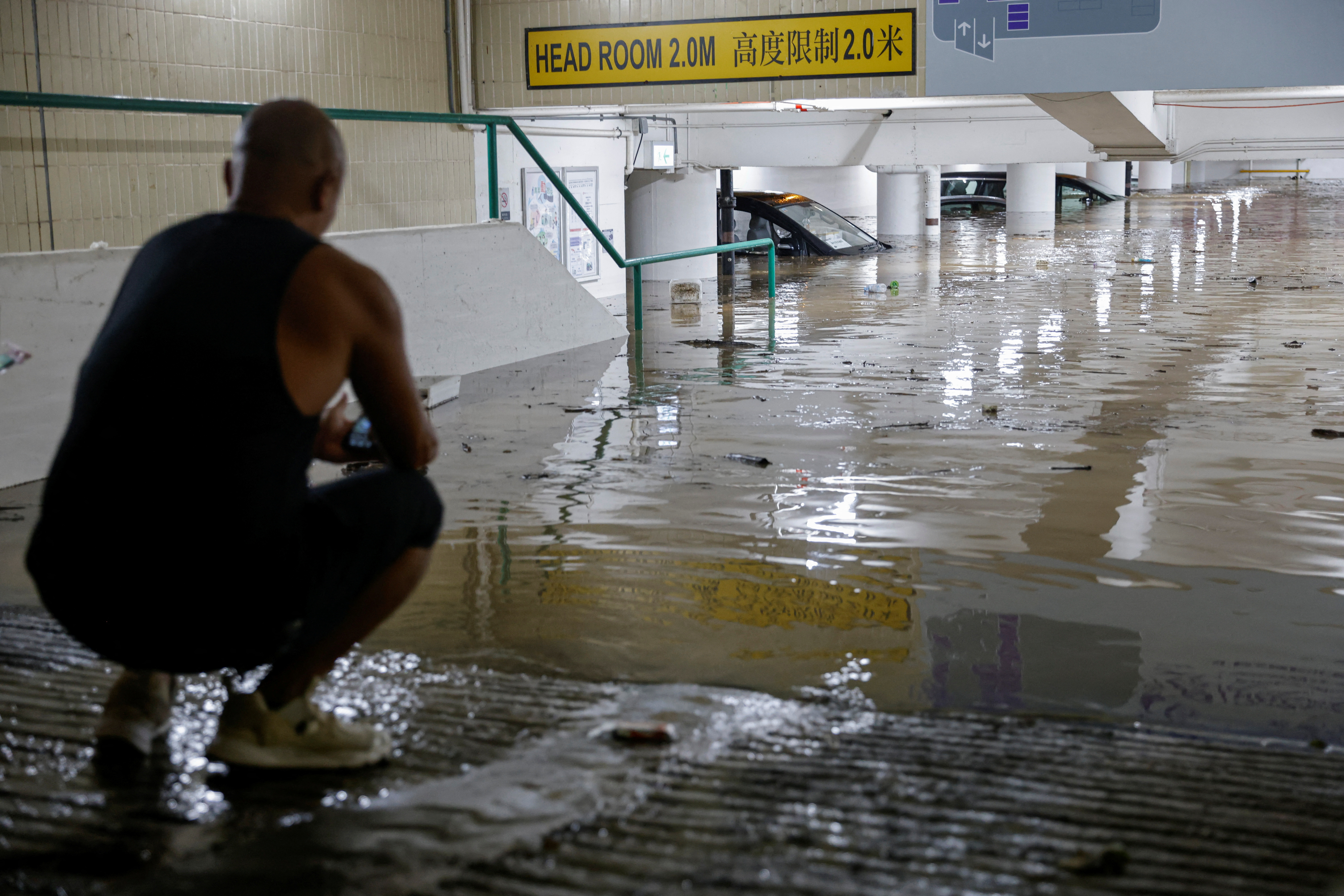 Vehicles are seen at a flooded packing lot during heavy rain, in Hong Kong
