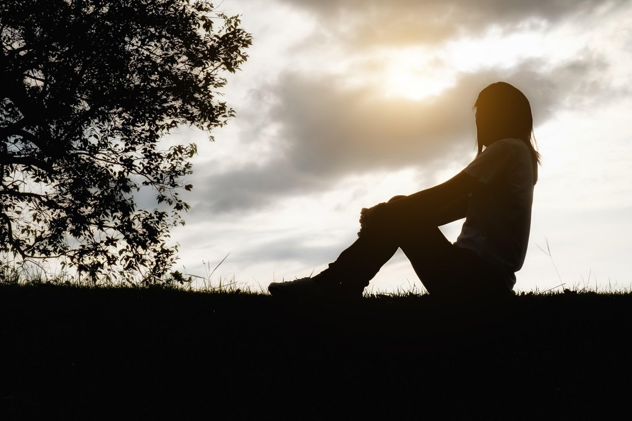 sad,depressed,woman,sitting,alone,field,during,beautiful,sunset,park background,solitude,silhouette,lifestyle, loneliness,