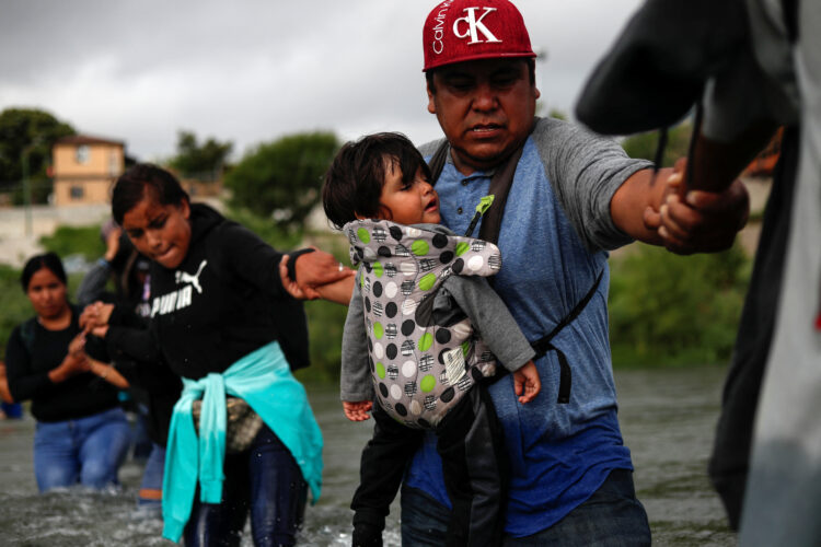 Migrants walk through the Rio Grande river seeking asylum into the U.S., as seen from Piedras Negras