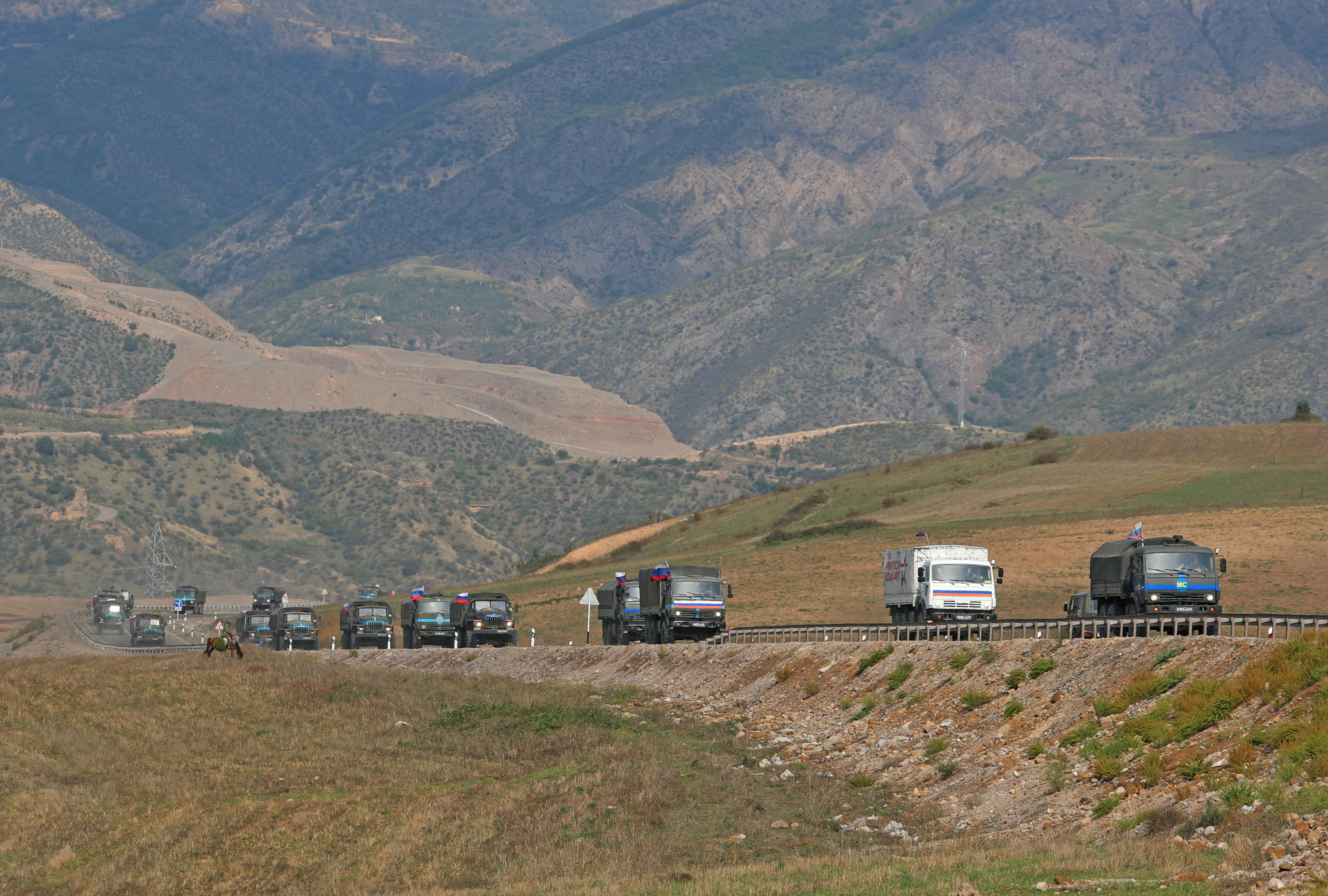 FILE PHOTO: Vehicles of Russian peacekeepers leaving Nagorno-Karabakh region pass an Armenian checkpoint near Kornidzor