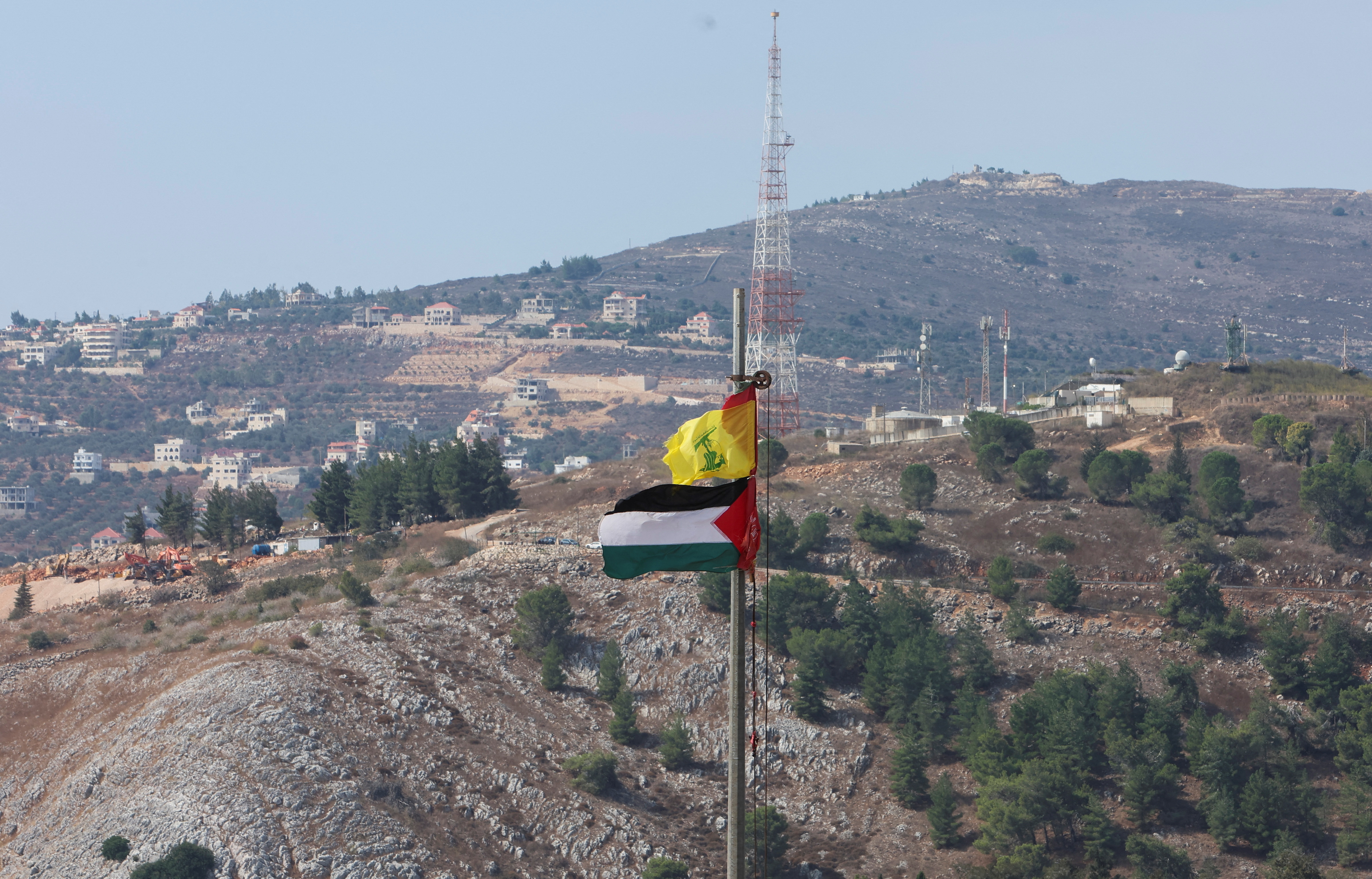 Palestinian and Hezbollah flags flutter in Khiam, near Lebanon's border with Israel