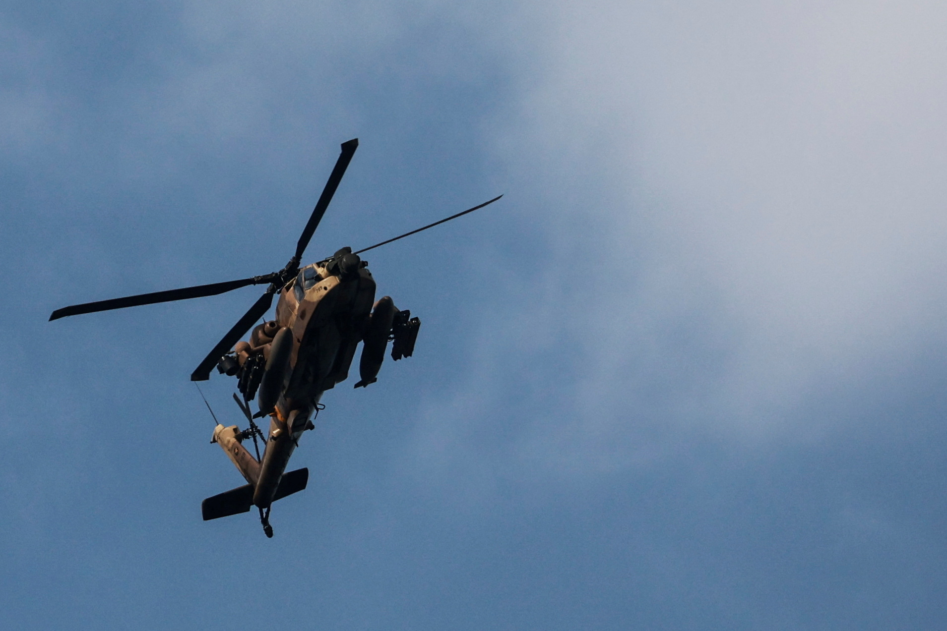 An Israeli Apache helicopter is seen in the skies over Israel's border with Lebanon, in northern Israel