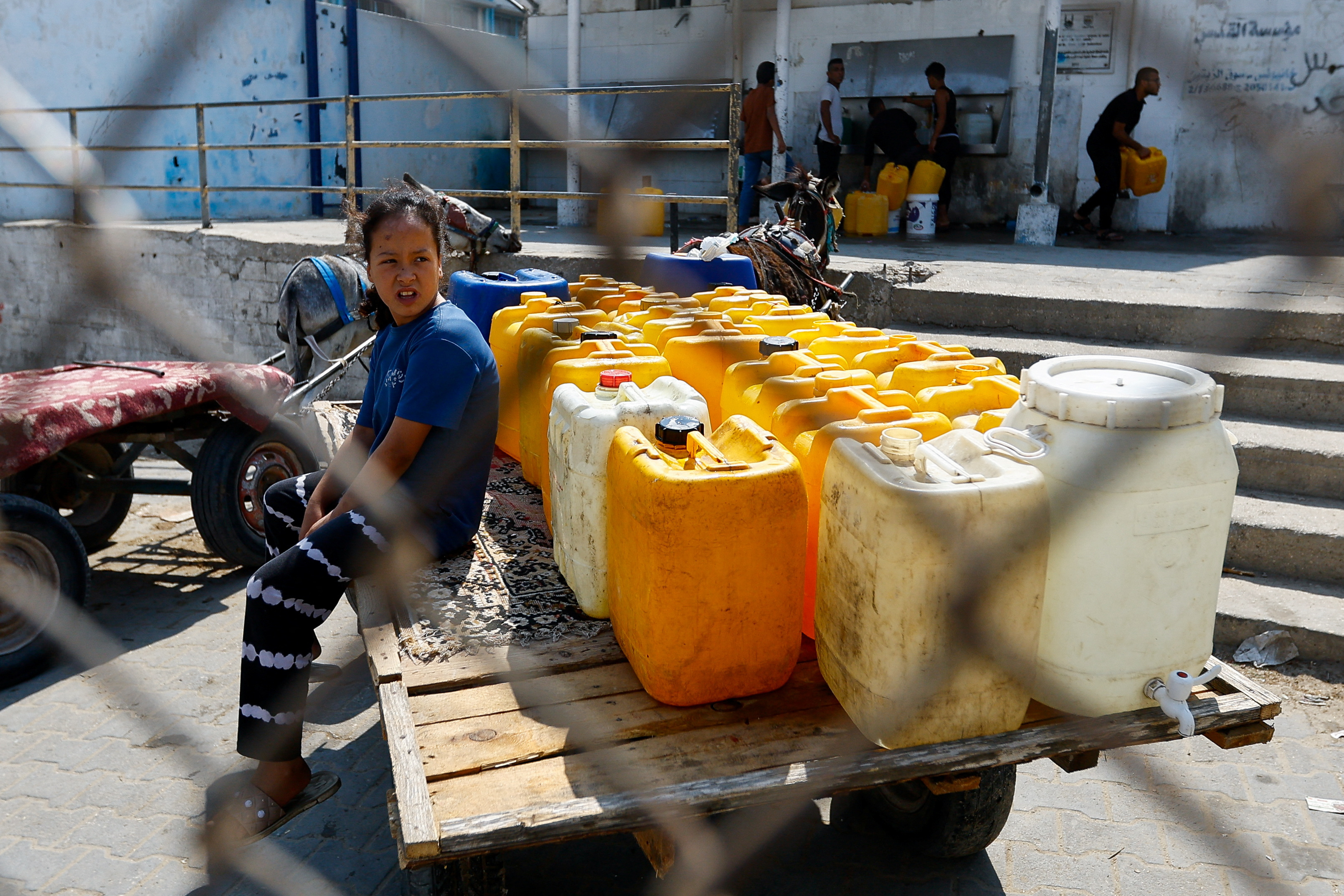 Palestinians gather to fill containers with water in the southern Gaza Strip