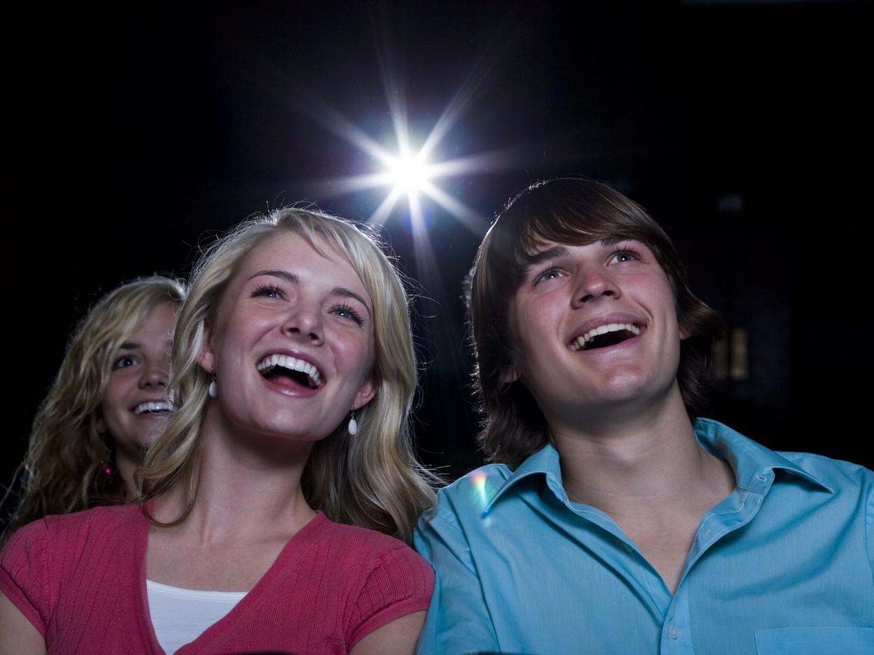 Boy and girl watching film at movie theater smiling