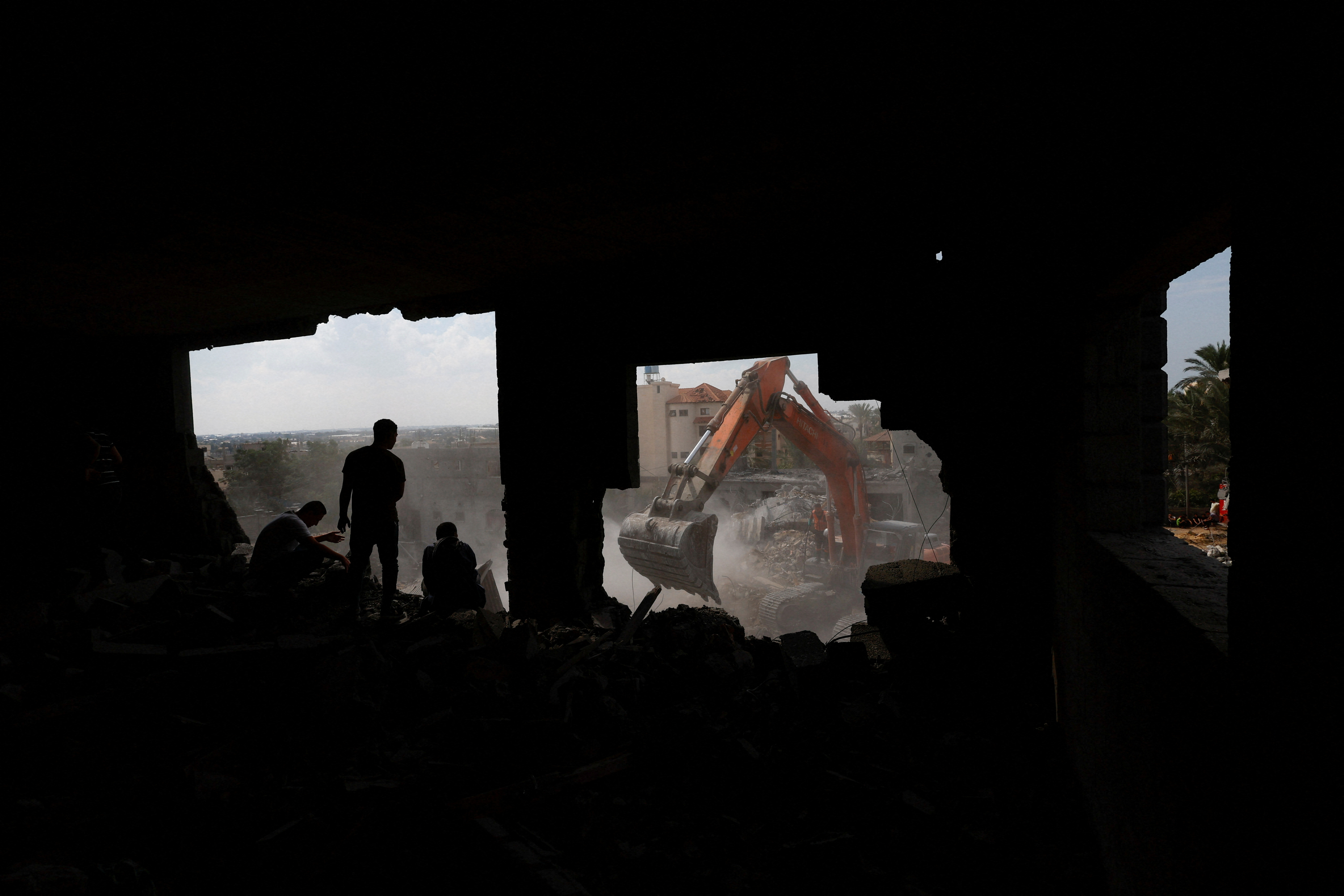 Palestinians work to remove the rubble of a house destroyed by Israeli strikes in Khan Younis