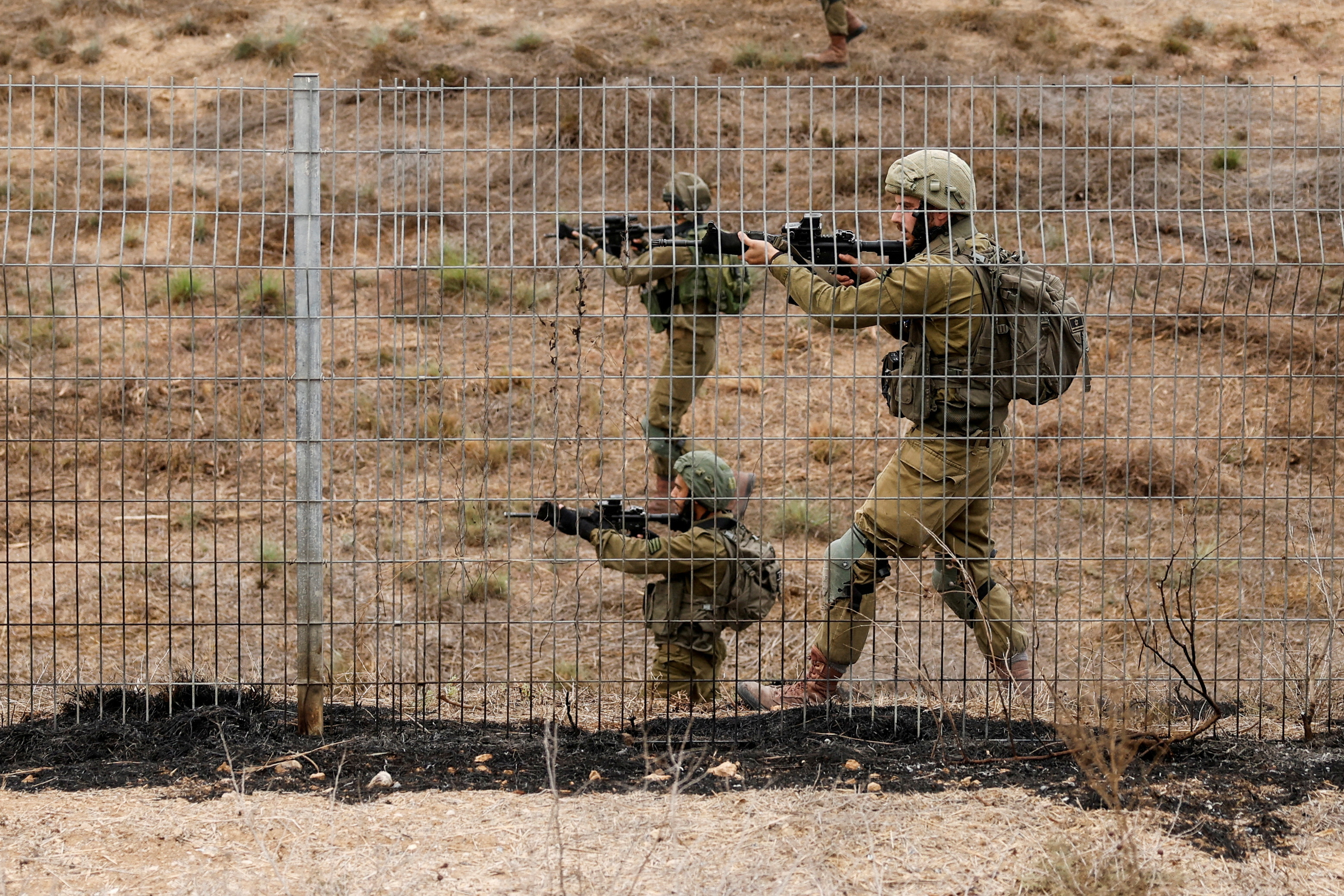 FILE PHOTO: Israeli soldiers scan an area while sirens sound as rockets from Gaza are launched towards Israel,, near Sderot, southern Israel