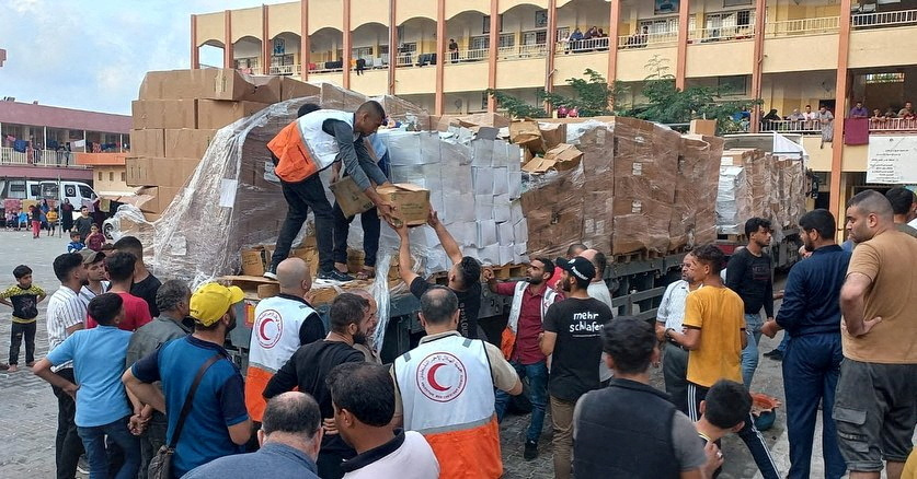 Members of the Palestine Red Crescent Society distribute aid to people in Khan Younis