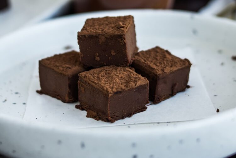 Cubes,Of,Chocolate,Candy,With,Cocoa,Drink,In,Background