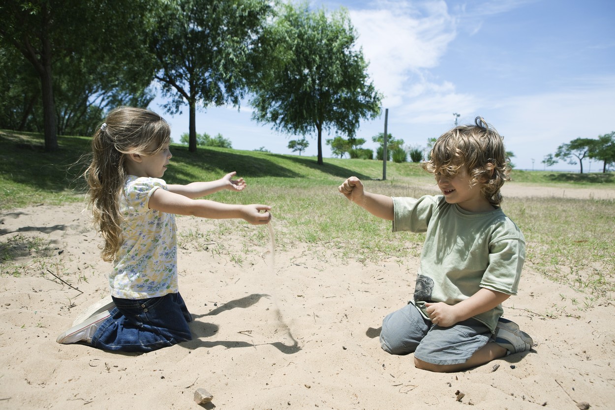 Young children playing in sand at park