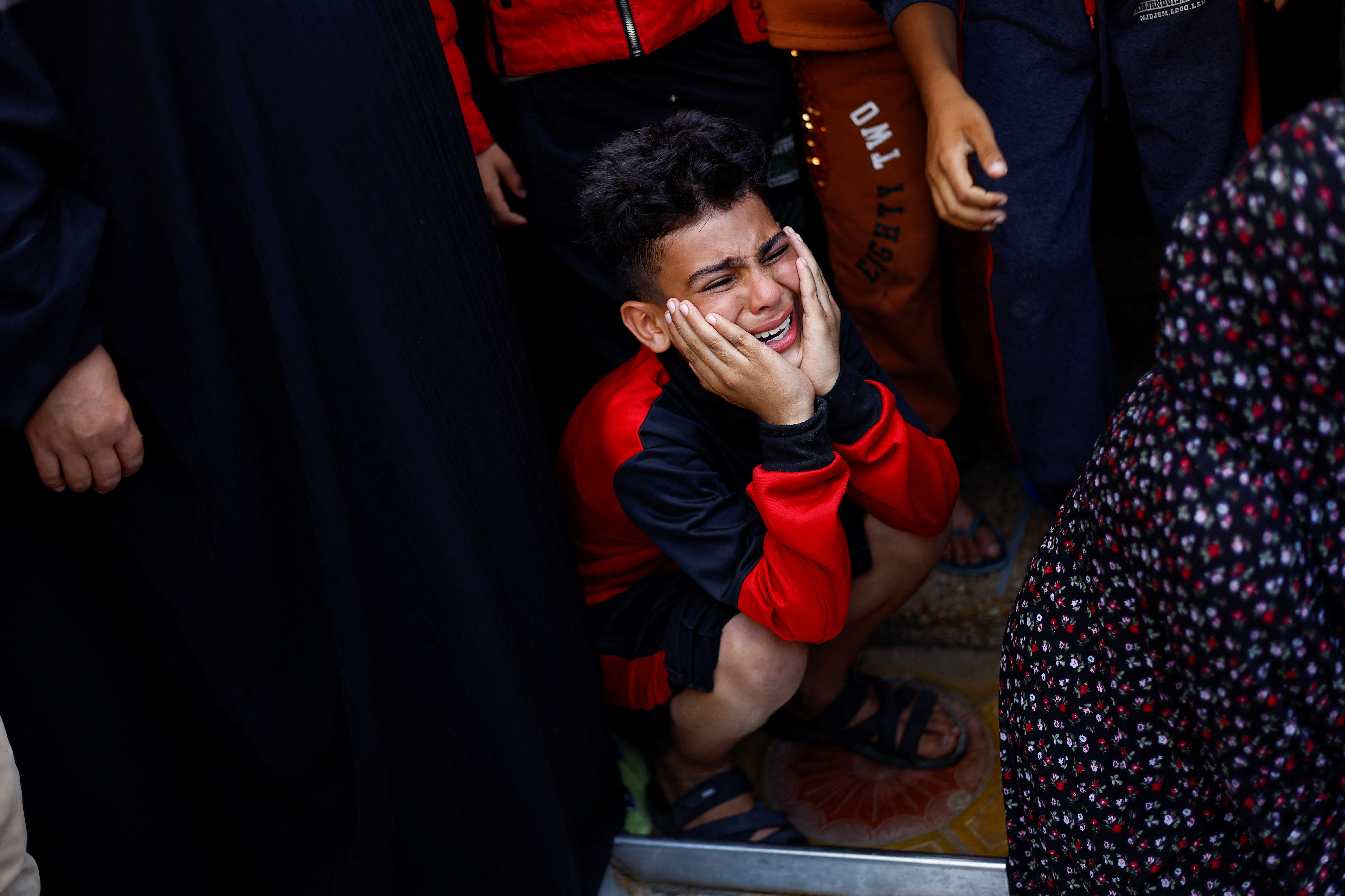 Palestinians react at a hospital, amid the ongoing conflict between Israel and Palestinian Islamist group Hamas, in Khan Younis