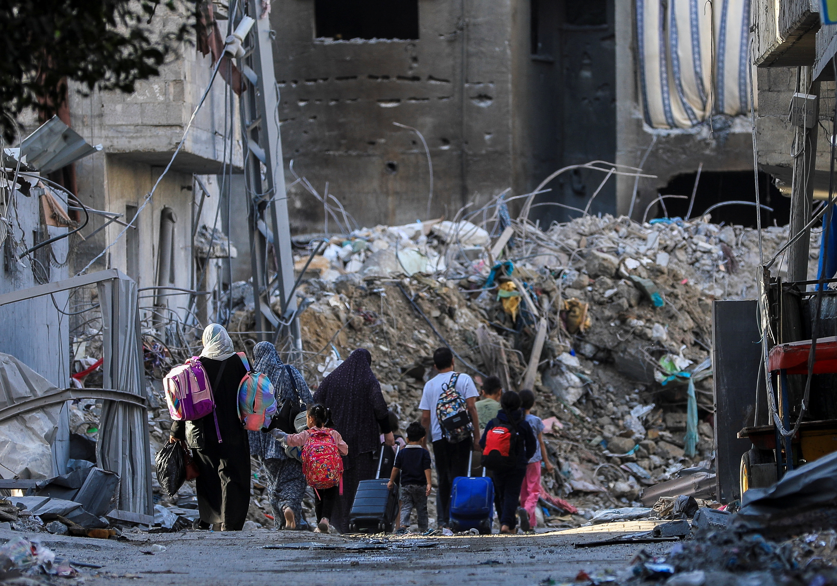 Palestinians carry their belongings as they flee their houses