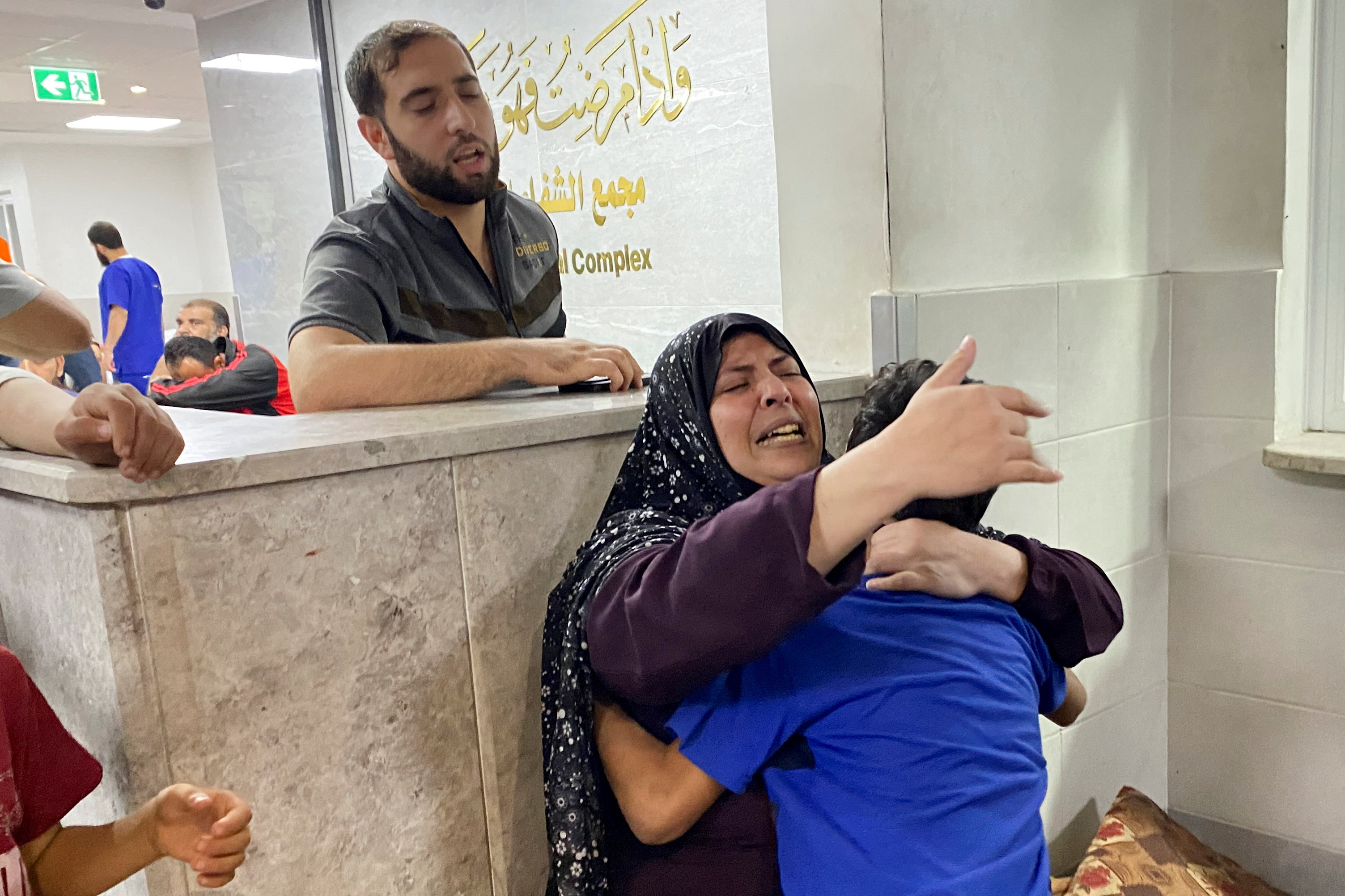 The mother of Palestinian Mohammed Abu Amira, who was killed in an Israeli strike, is comforted by her son