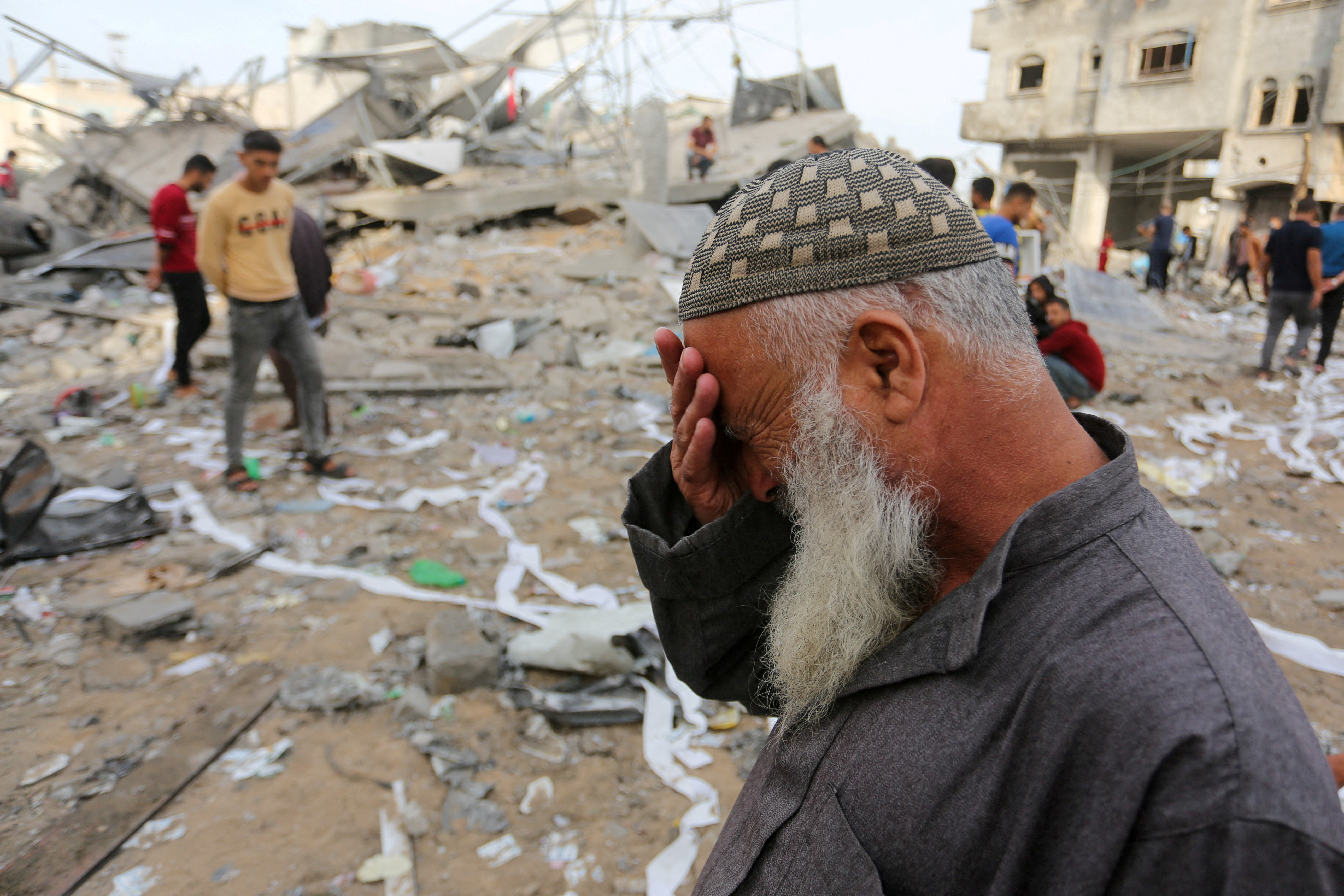 Palestinians inspect the site of an Israeli strike on a house belonging to Fojo family, in Rafah