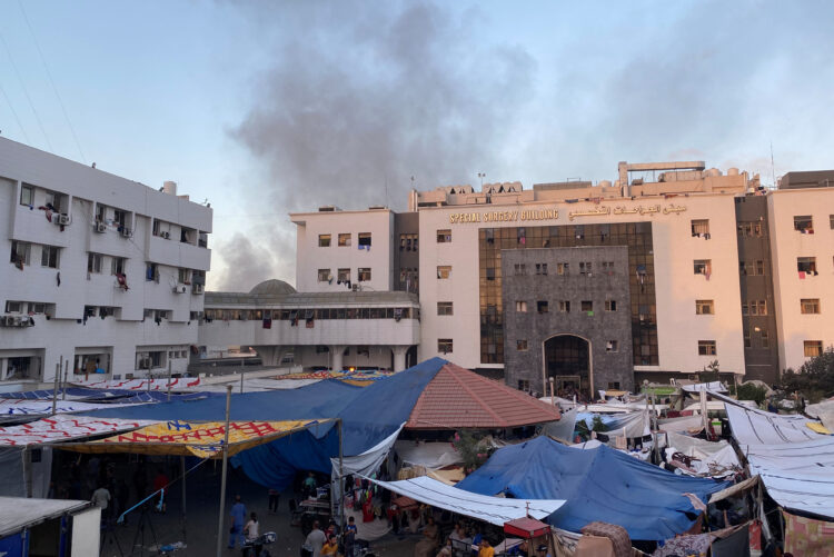 Smoke rises as displaced Palestinians take shelter at Al Shifa hospital, amid the ongoing conflict between Hamas and Israel, in Gaza City