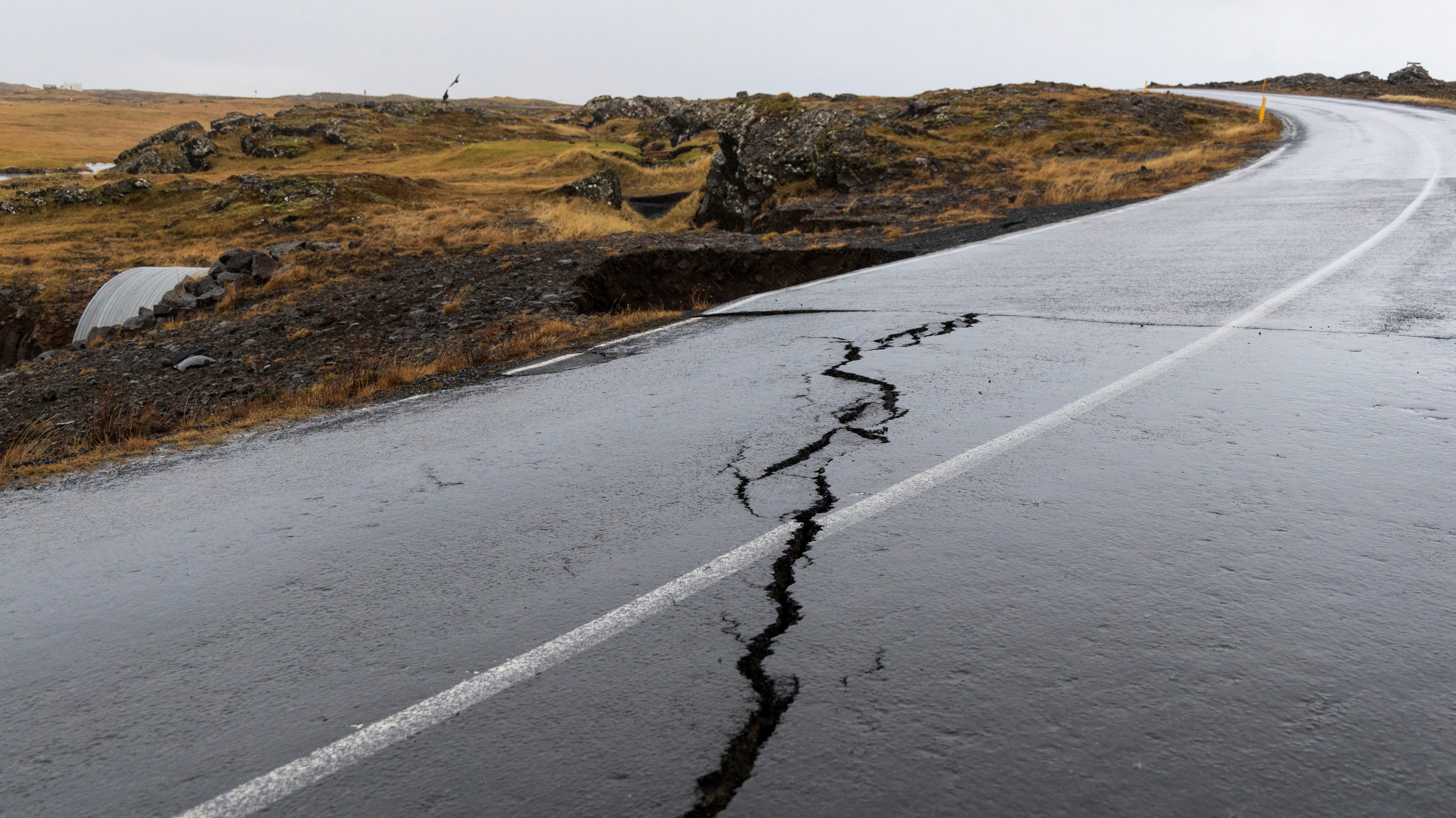 Cracks emerge on a road due to volcanic activity near a golf course, in Grindavik