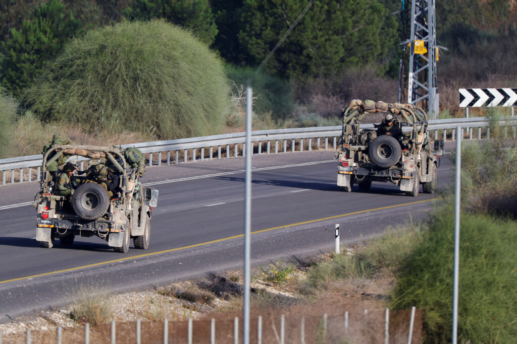 Israeli soldiers travel in military vehicles near Gaza, as seen from southern Israel