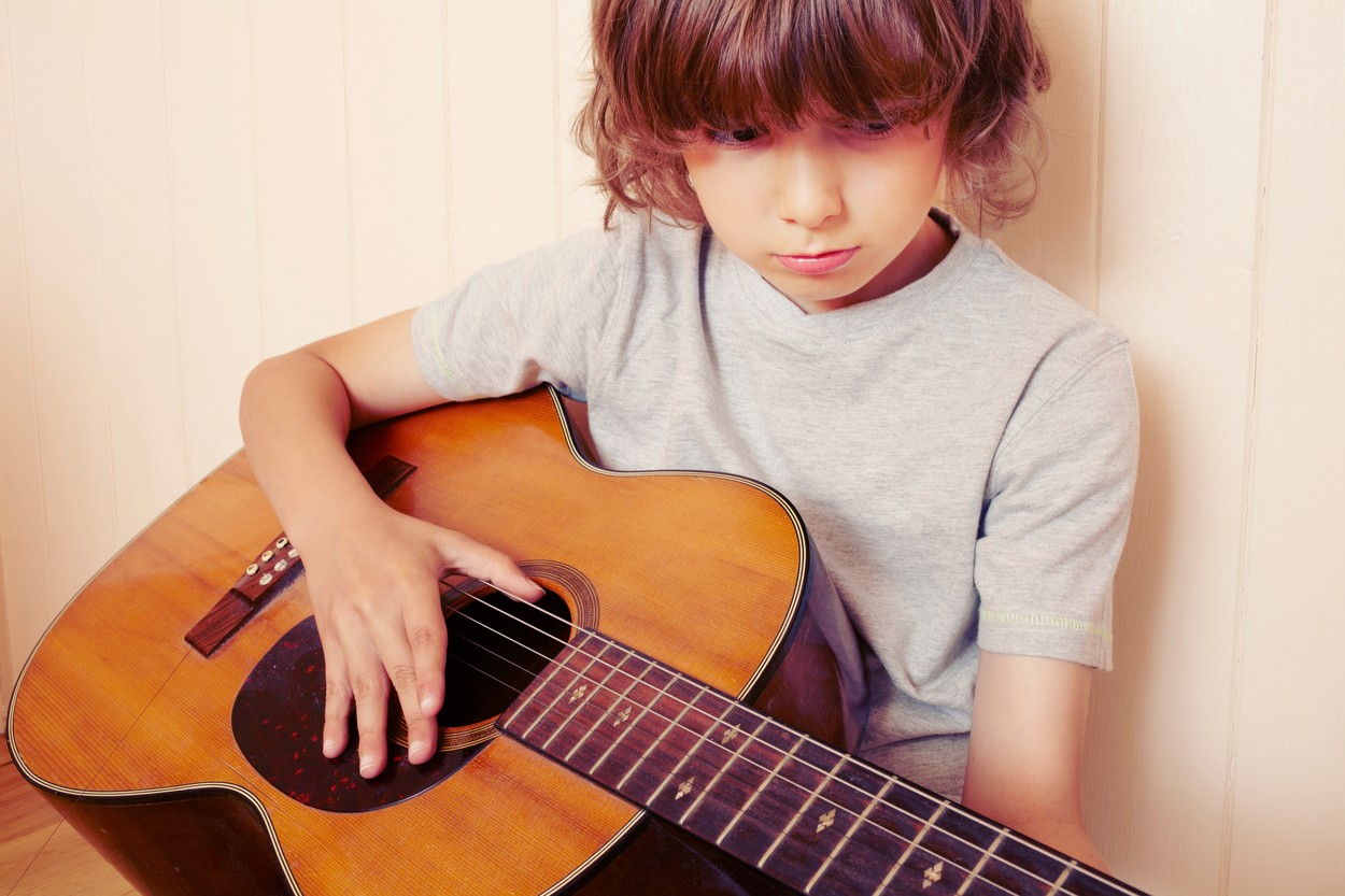 Boy playing guitar indoors